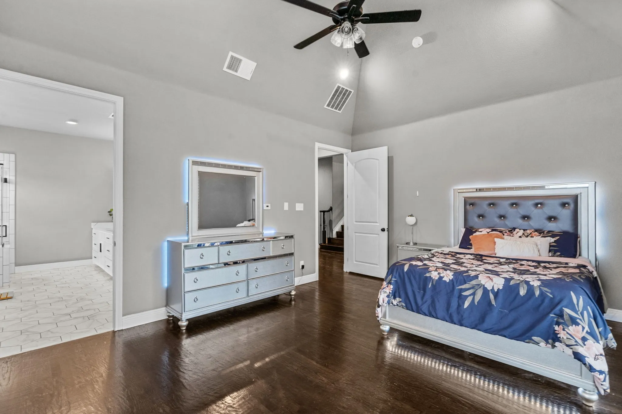 Tiled bedroom with ensuite bath, high vaulted ceiling, and ceiling fan
