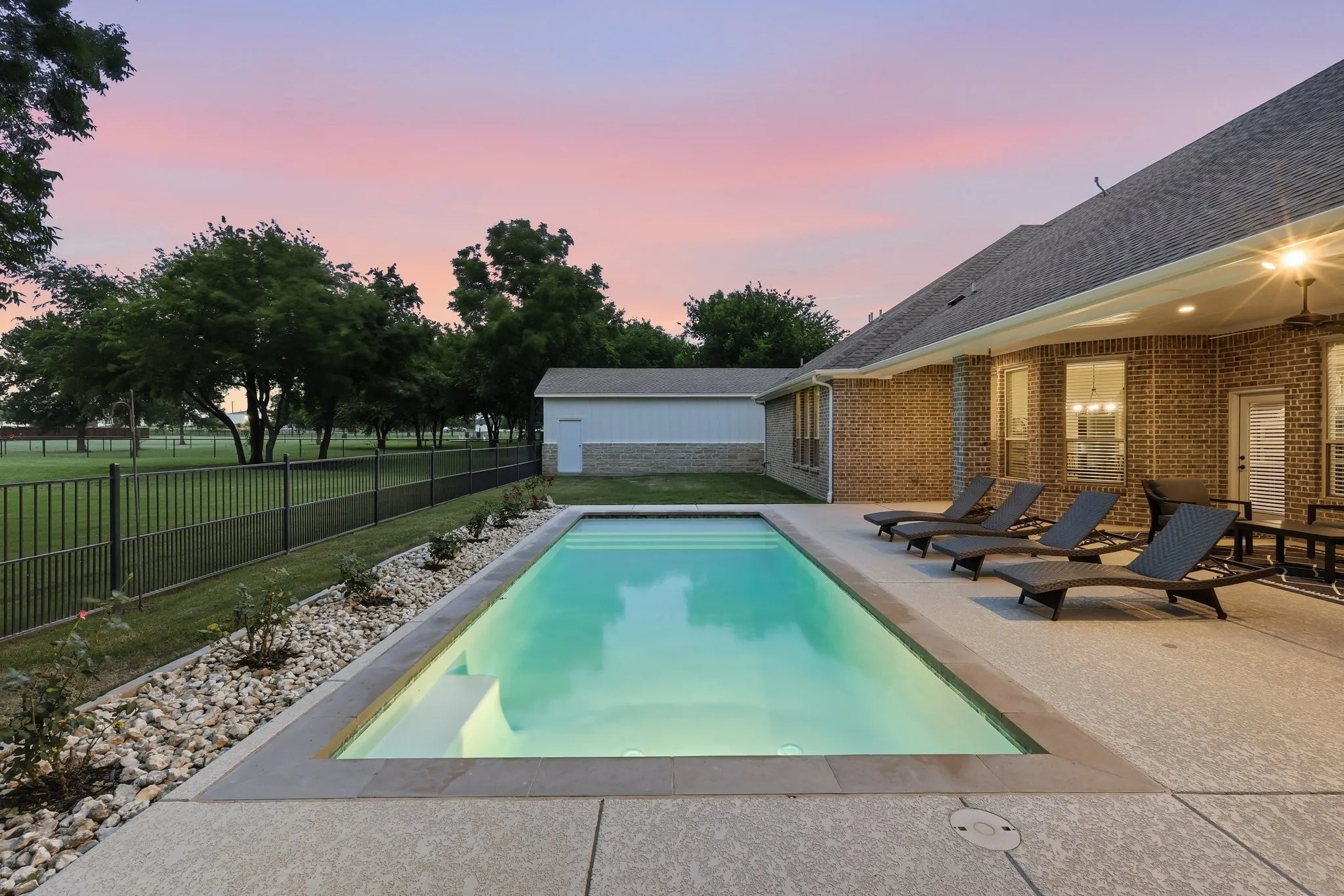 Rectangular inground pool with integrated steps and surrounding concrete patio