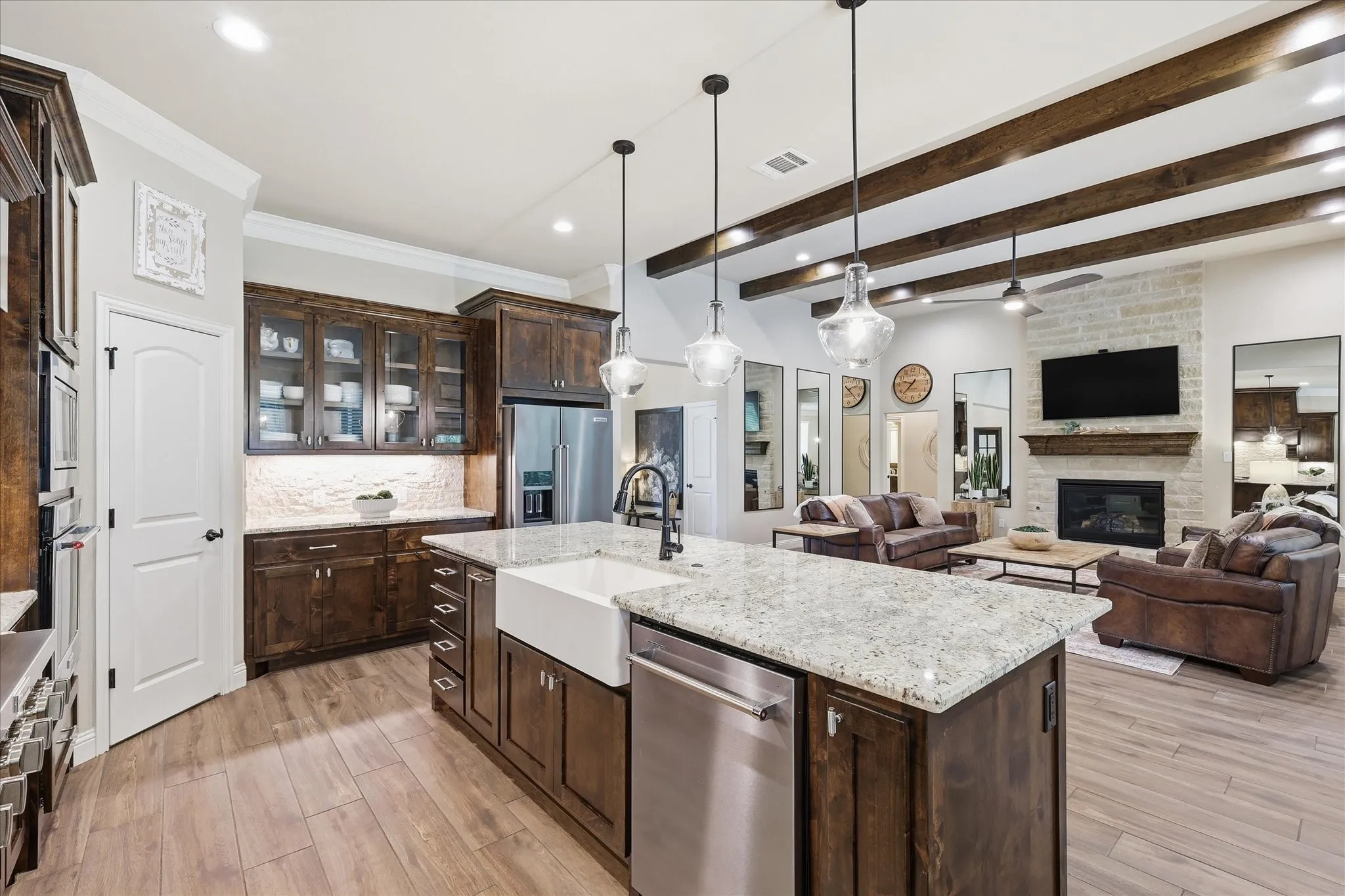Kitchen island with a farmhouse sink and granite countertop, featuring wood-finish flooring