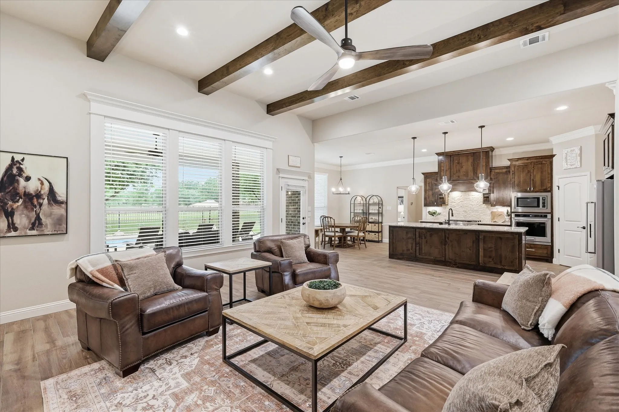 Spacious living area featuring exposed ceiling beams and wood-finish flooring