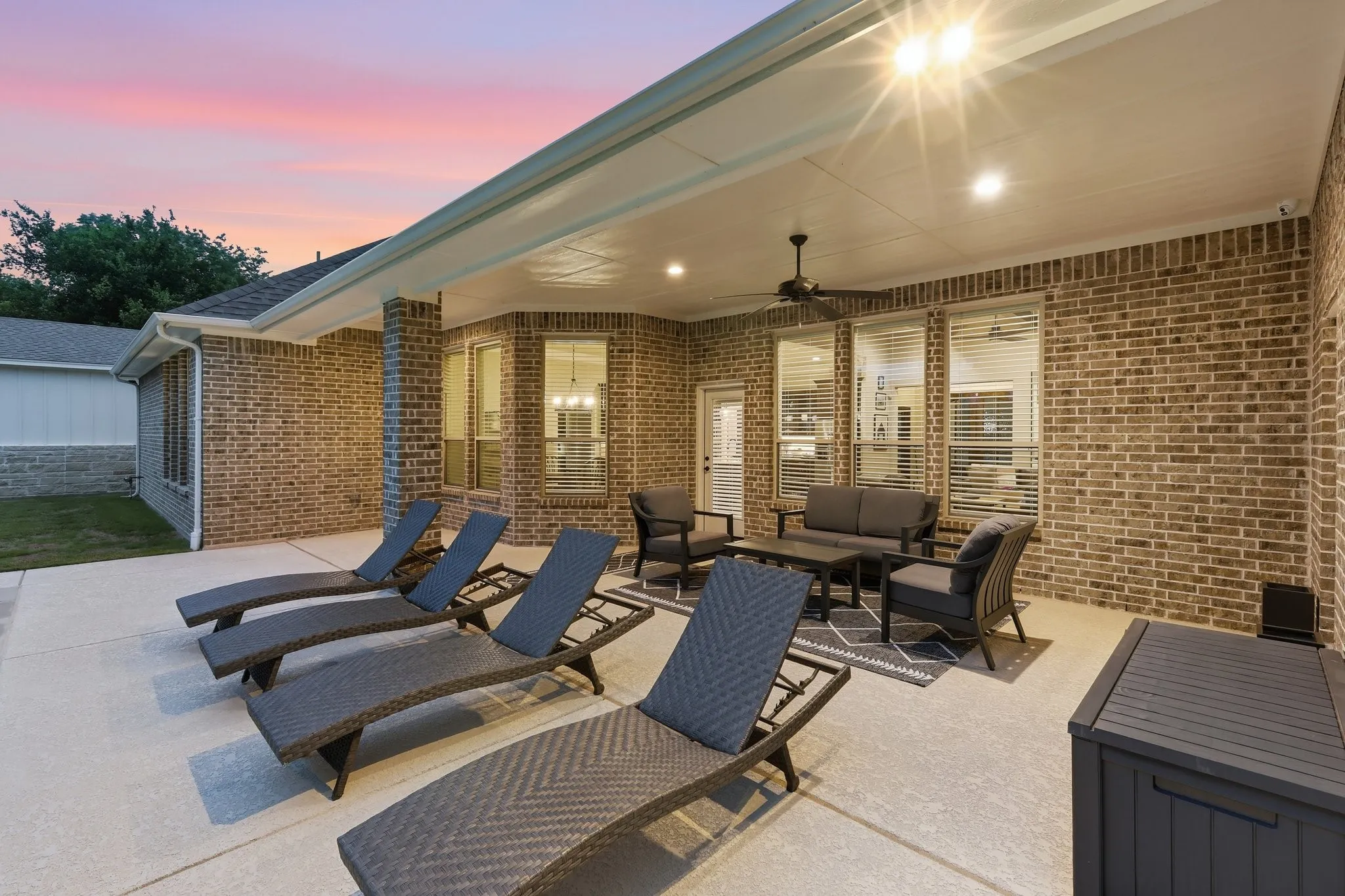 Expansive covered patio featuring a ceiling fan, recessed lighting, and a brick exterior