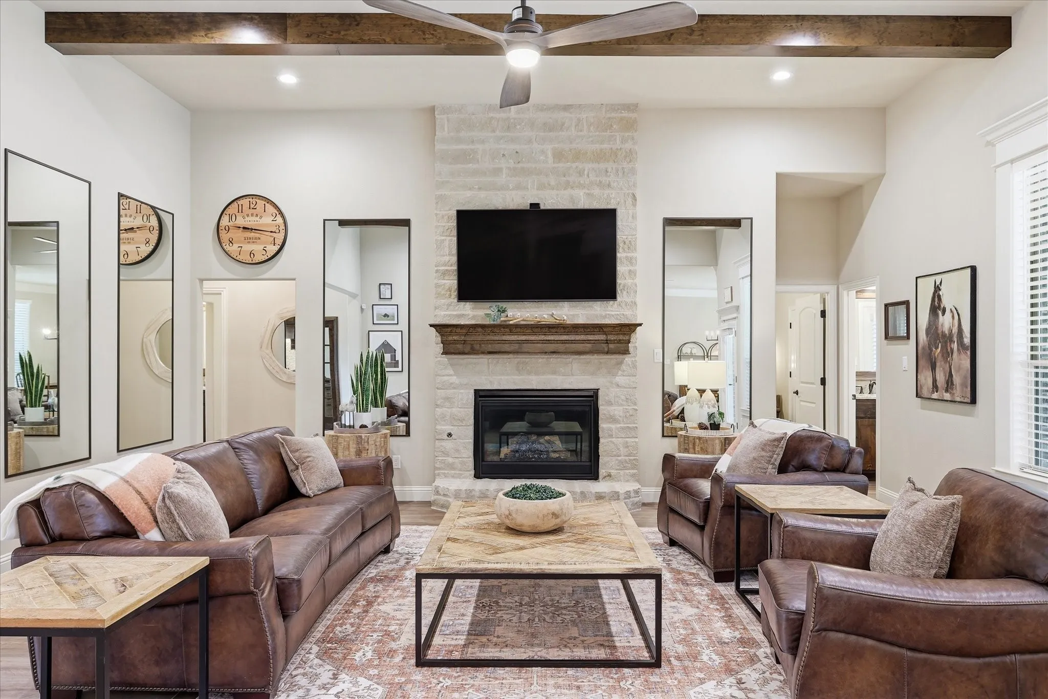 Vaulted living room featuring a stone-clad fireplace with a wood mantel, exposed beam accents, and recessed lighting