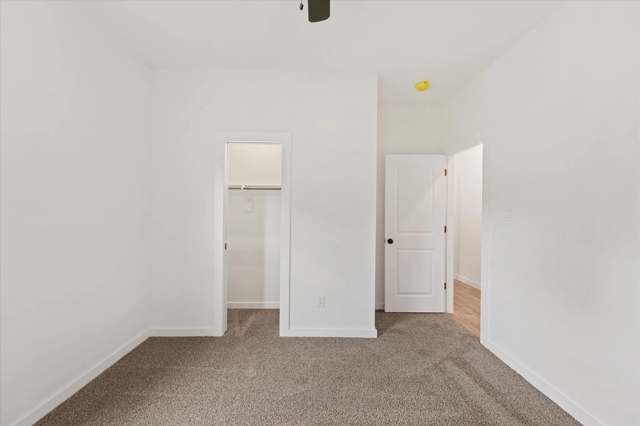 Interior room featuring neutral-toned carpet flooring and white painted walls