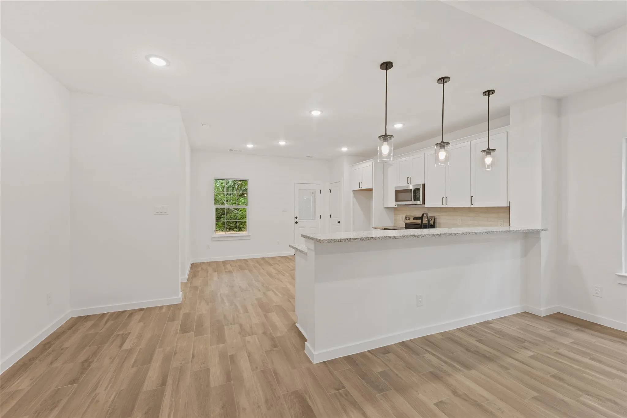 Open-concept living space featuring wood-finish flooring throughout