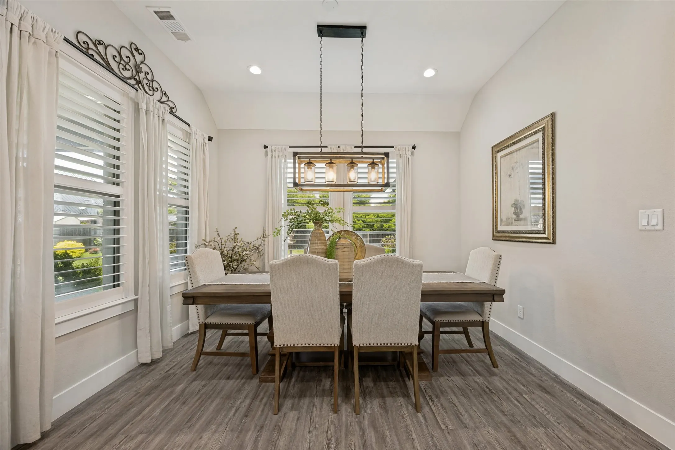 Dining area featuring wood-finish flooring, a linear chandelier with exposed bulbs, and recessed lighting