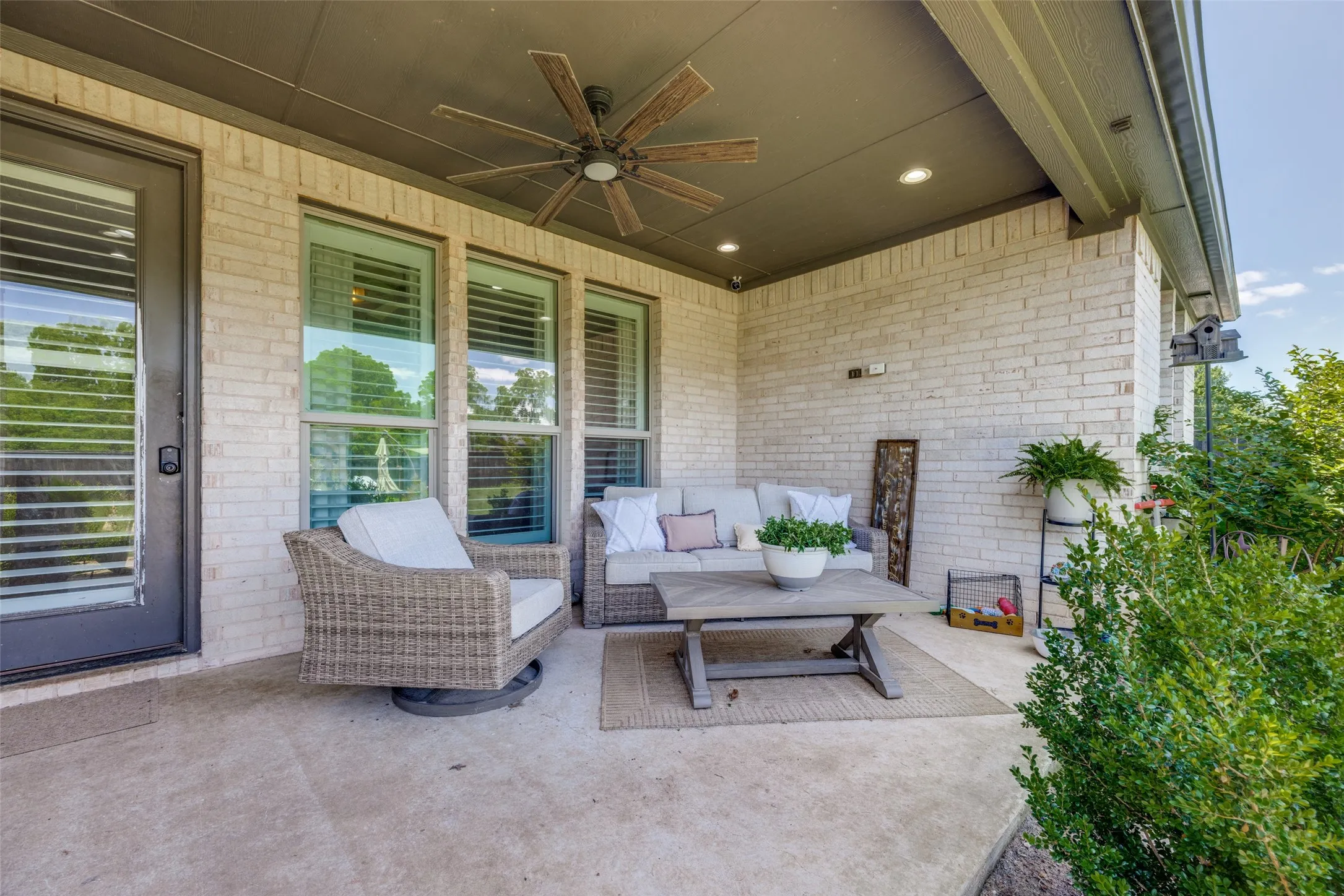 Covered patio featuring a ceiling fan, recessed lighting, and brick exterior walls