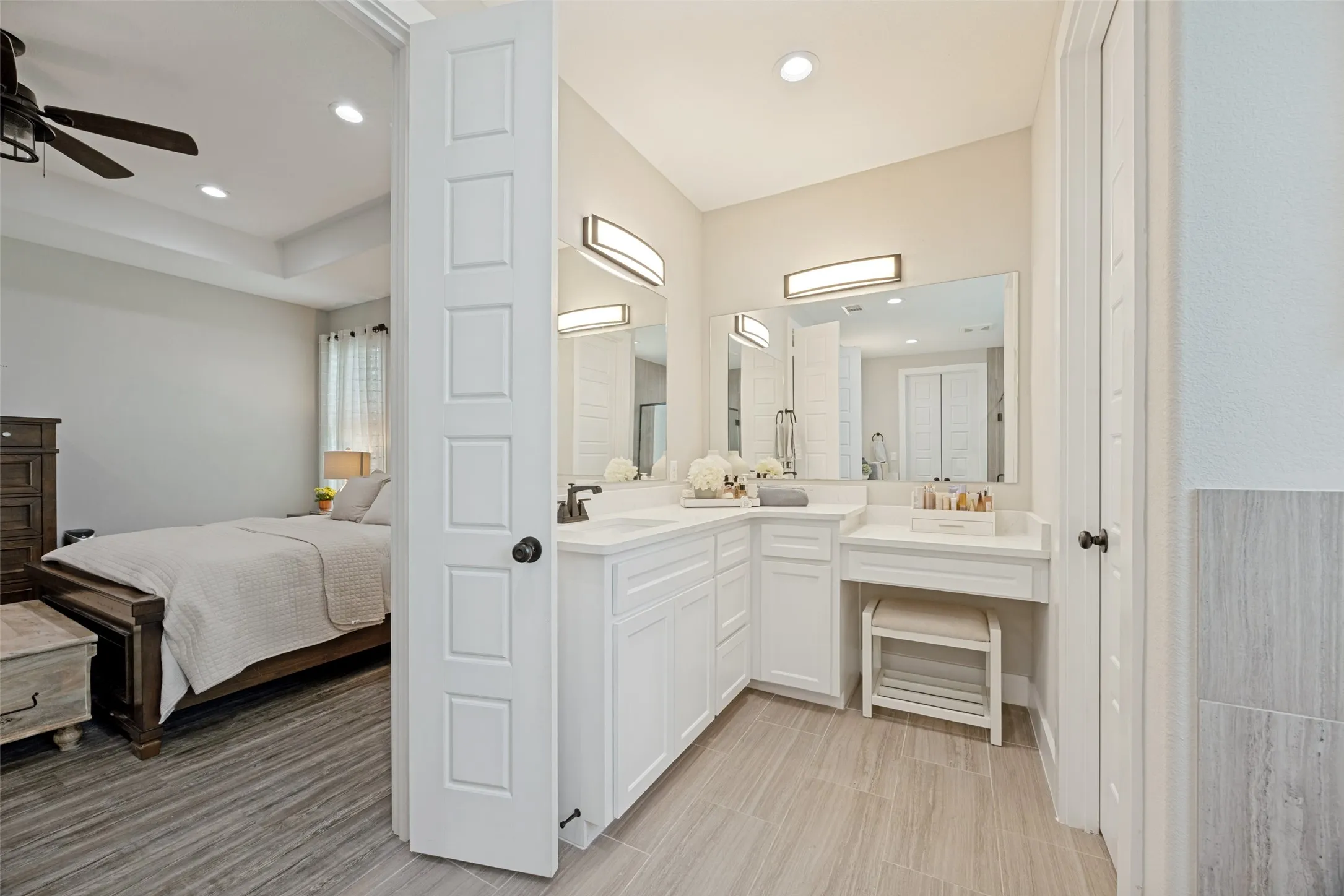 Primary bath has separate vanities and sink, also a makeup area and private toilet to the side.