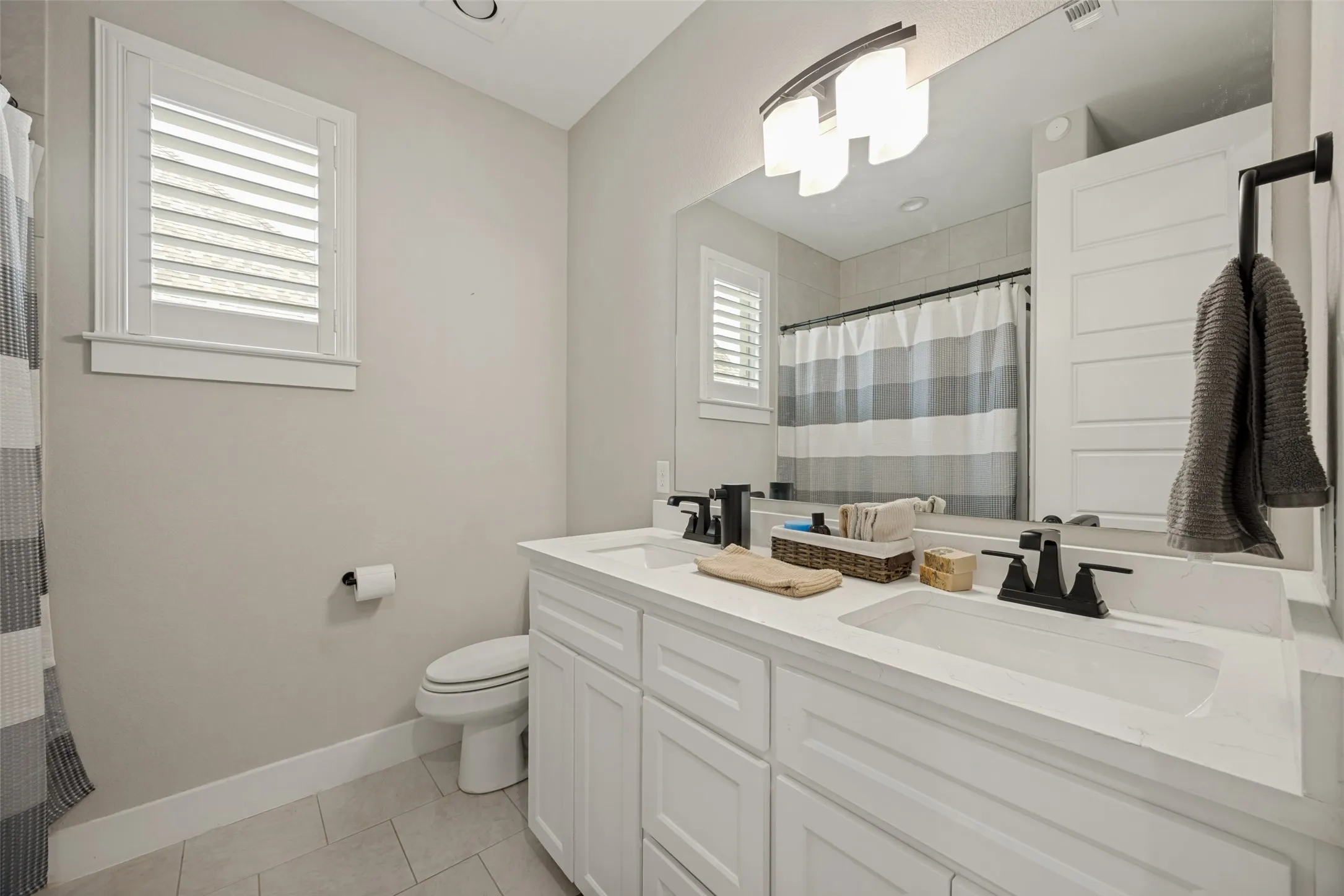 Double vanity with white cabinetry, integrated sinks, and matte black fixtures