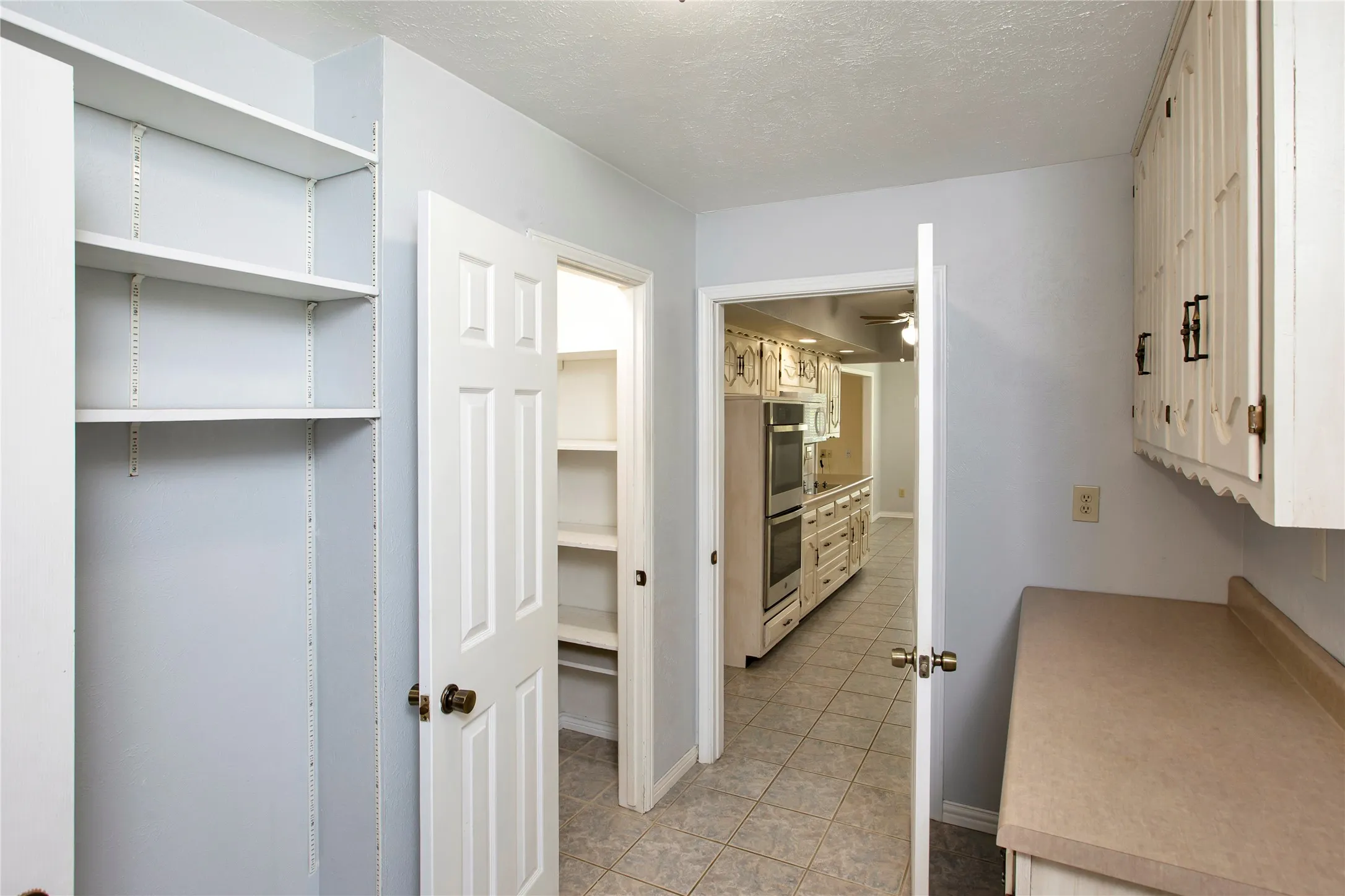 View#1 Into Pantry, Butler Cab/Counter & Hanging Storage & Through Into Kitchen.