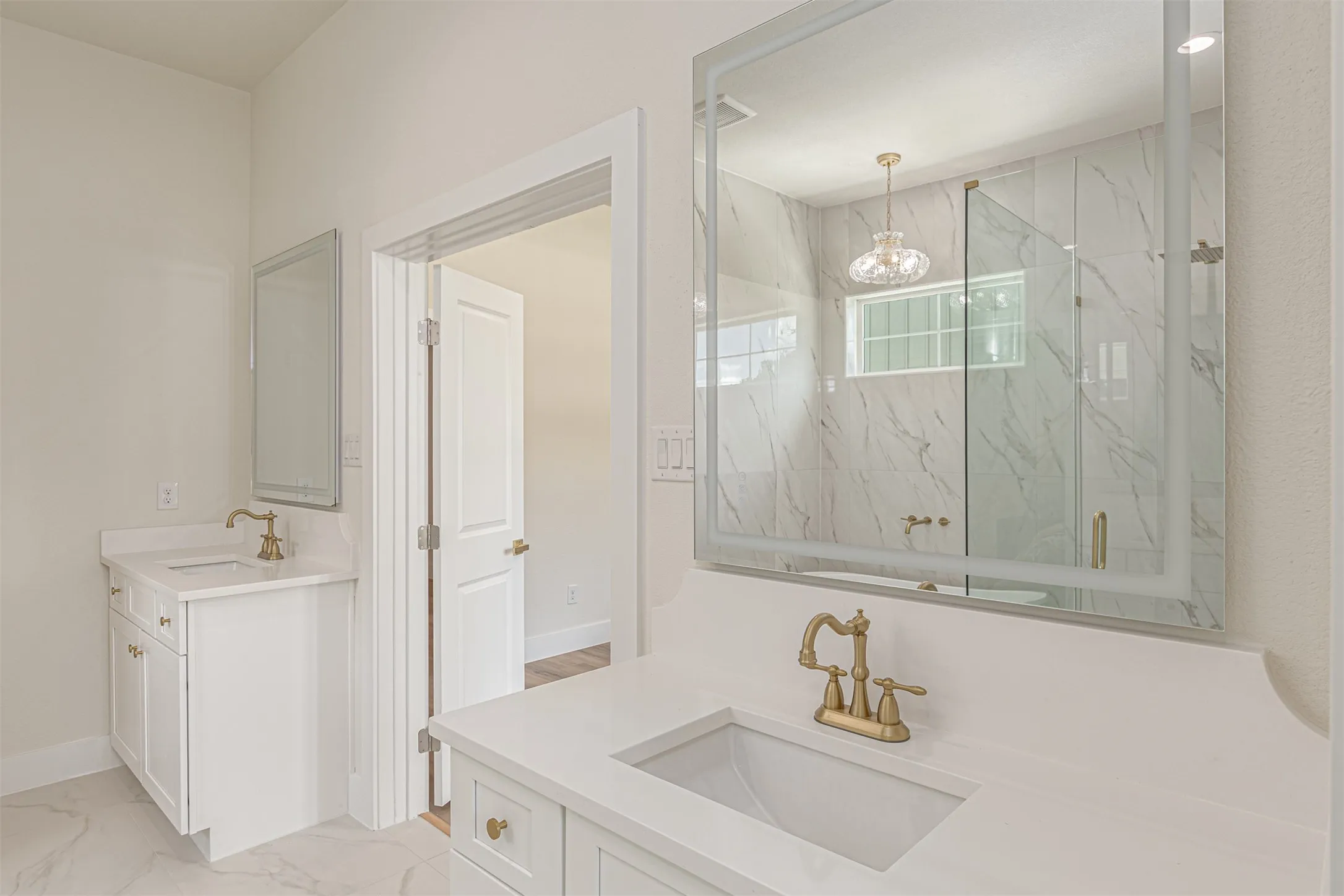 Dual vanity featuring white cabinetry, quartz countertops, and brass-finish fixtures