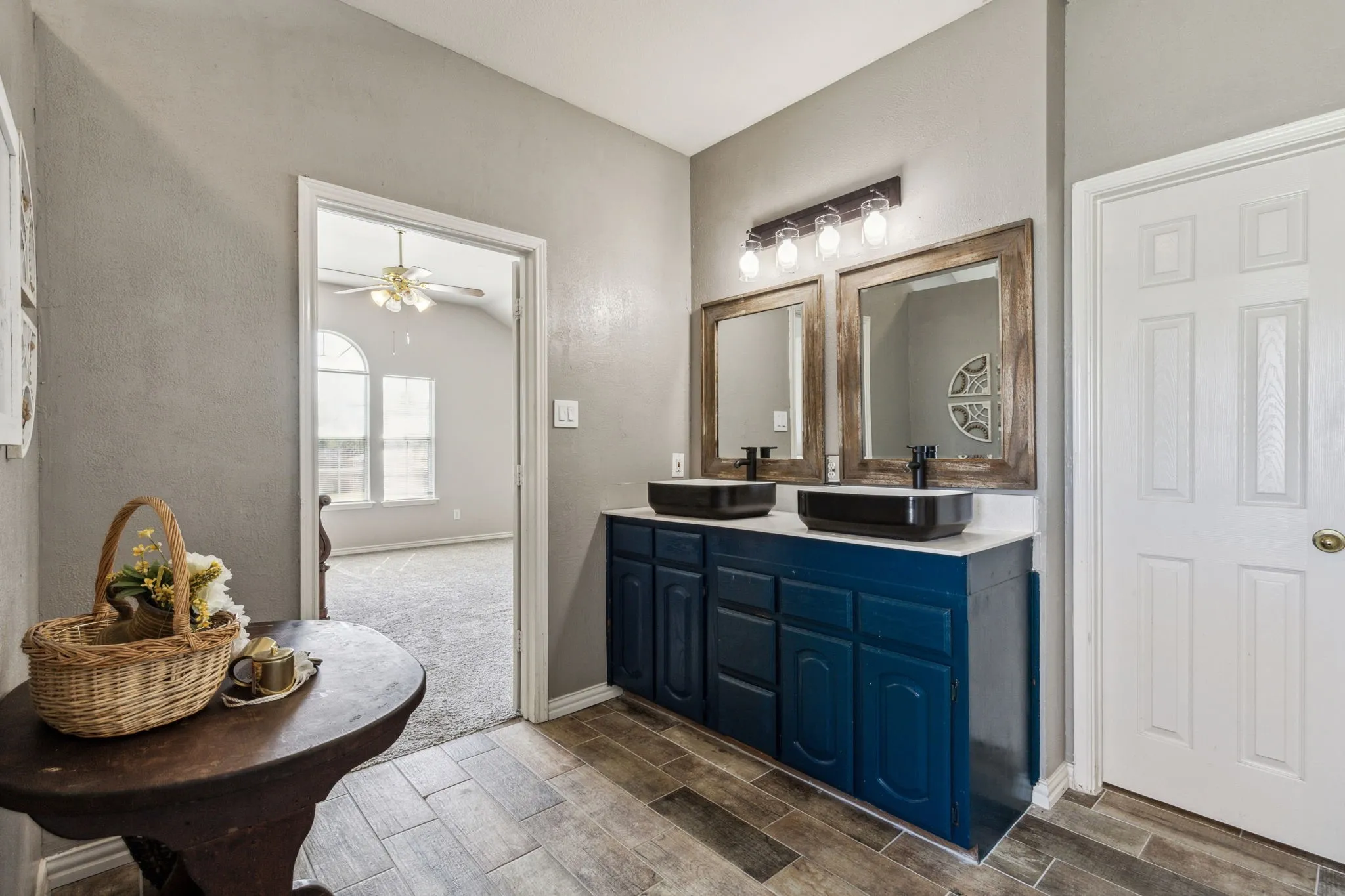 Primary bath boasts vessel sinks, and tile floors.