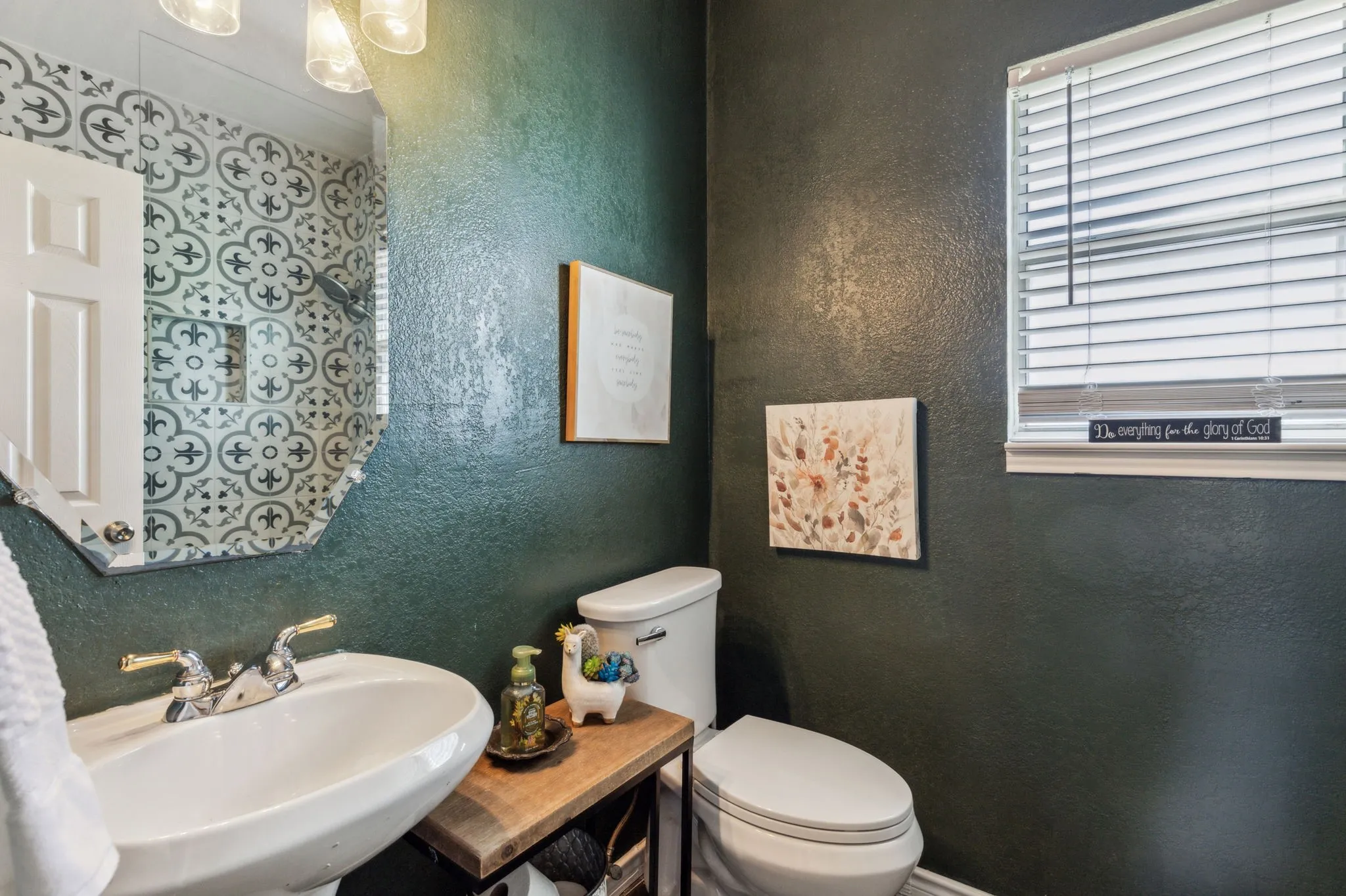 Full bath in downstairs adjacent to living area, with large shower, pedestal sink and stunning stone floors.