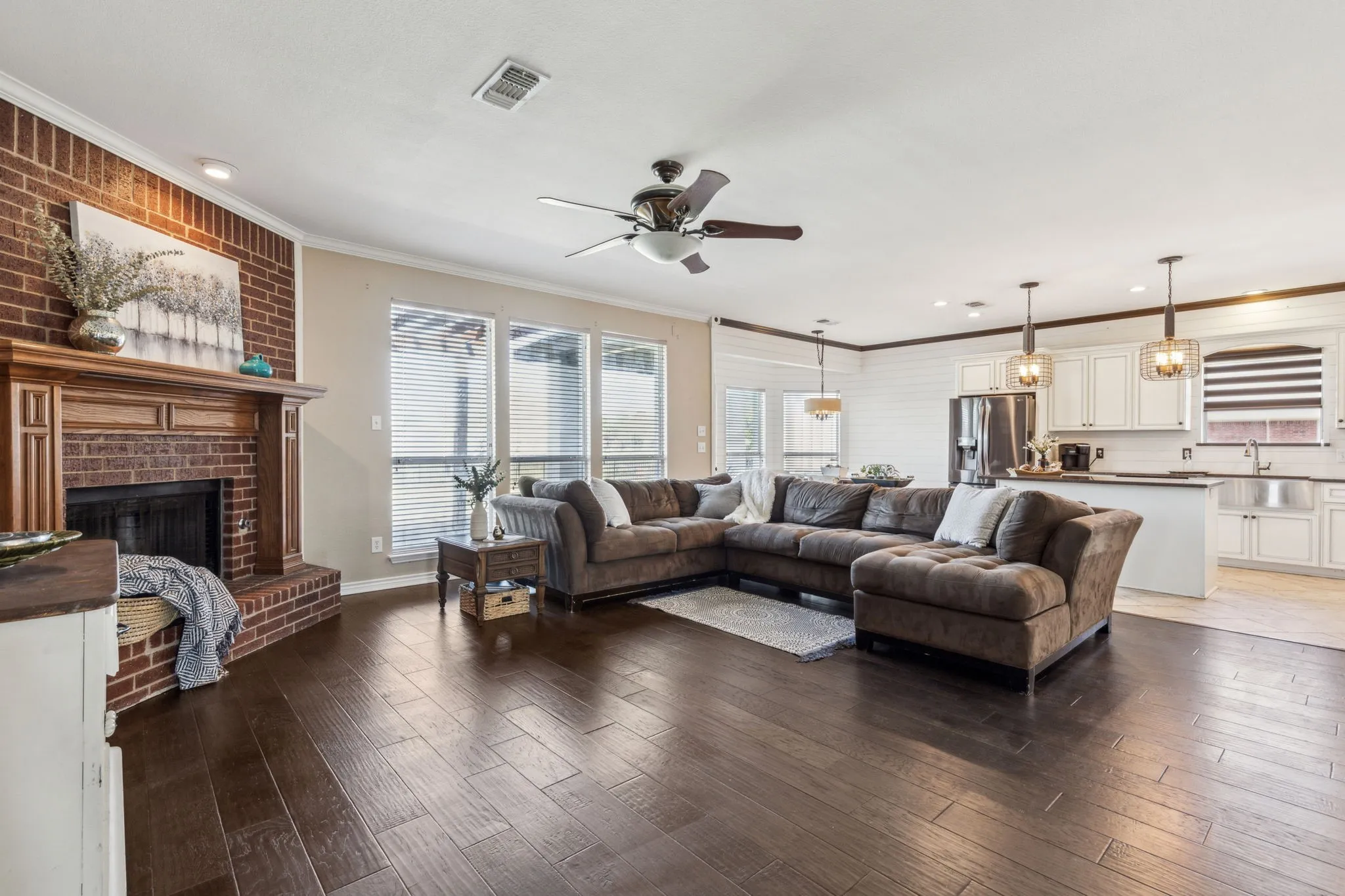 Check out this main living space with a spacious open floor plan into the kitchen, lots of natural light, crown molding, gas fireplace, perfect for time with family and entertaining.