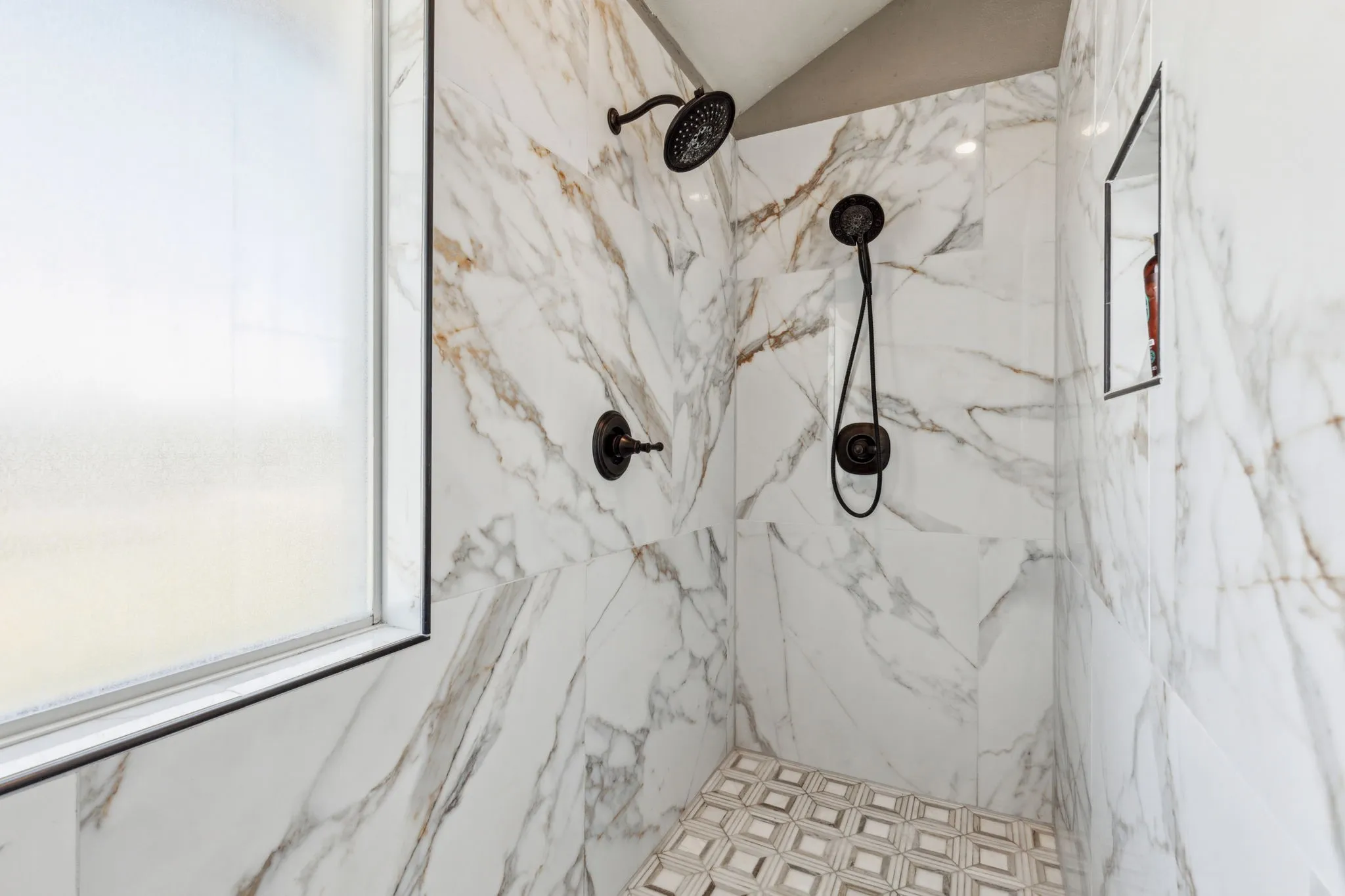 Step into this beautiful oversized marble shower with double shower heads.