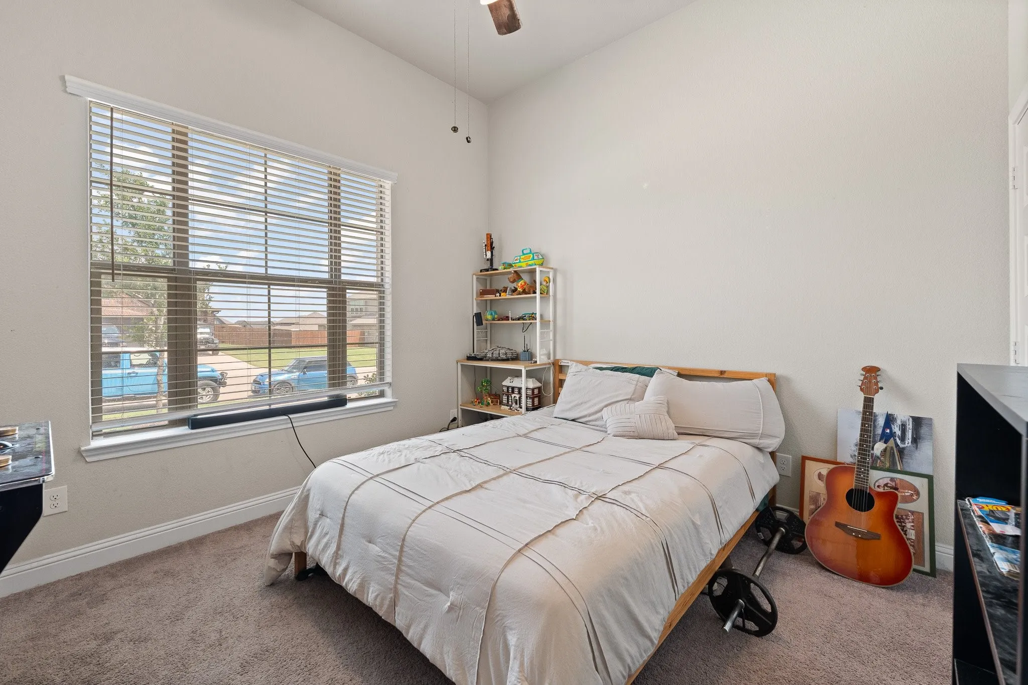 Recessed window with blinds, carpet flooring, a ceiling fan, and painted walls