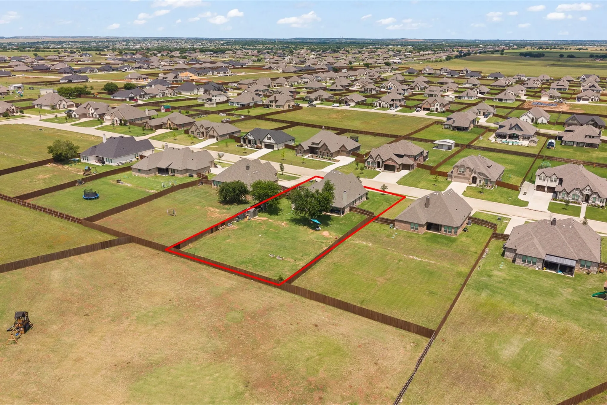 Aerial perspective of a suburban neighborhood featuring single-story homes with shingle roofs and brick exteriors