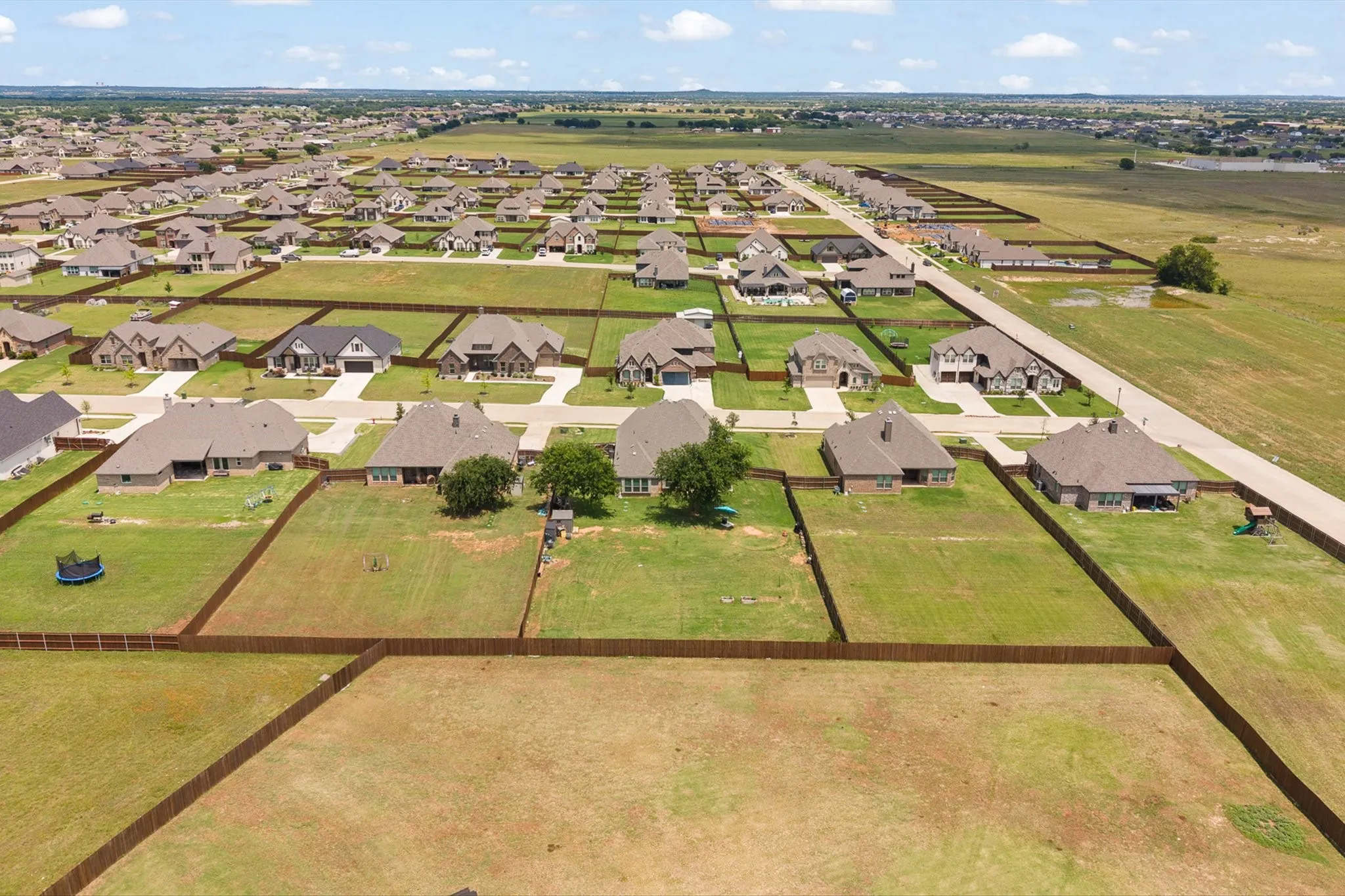 Expansive residential development featuring numerous single-story homes, each with individual fenced backyards