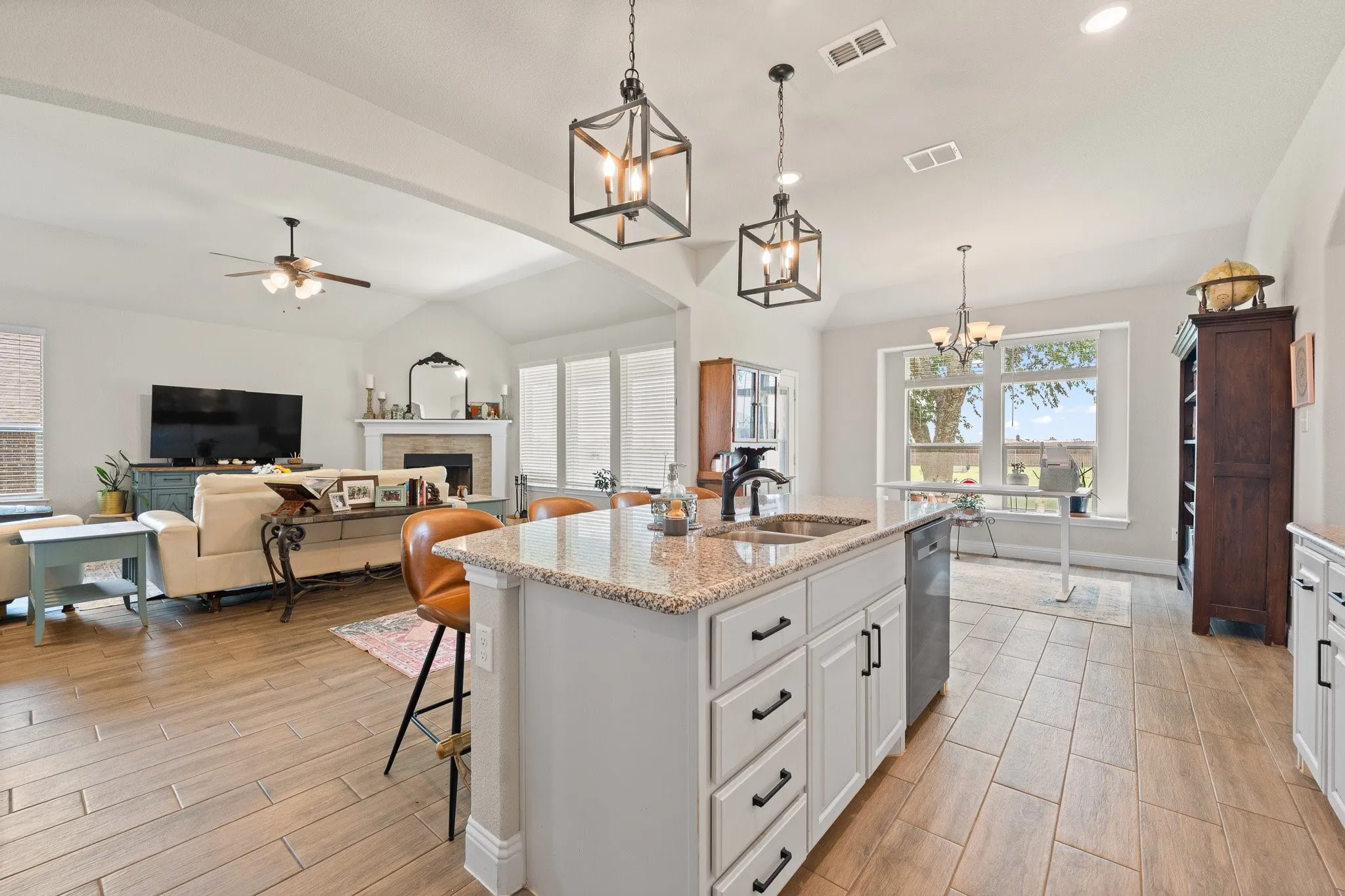 Open-concept kitchen and living area featuring wood-finish tile flooring