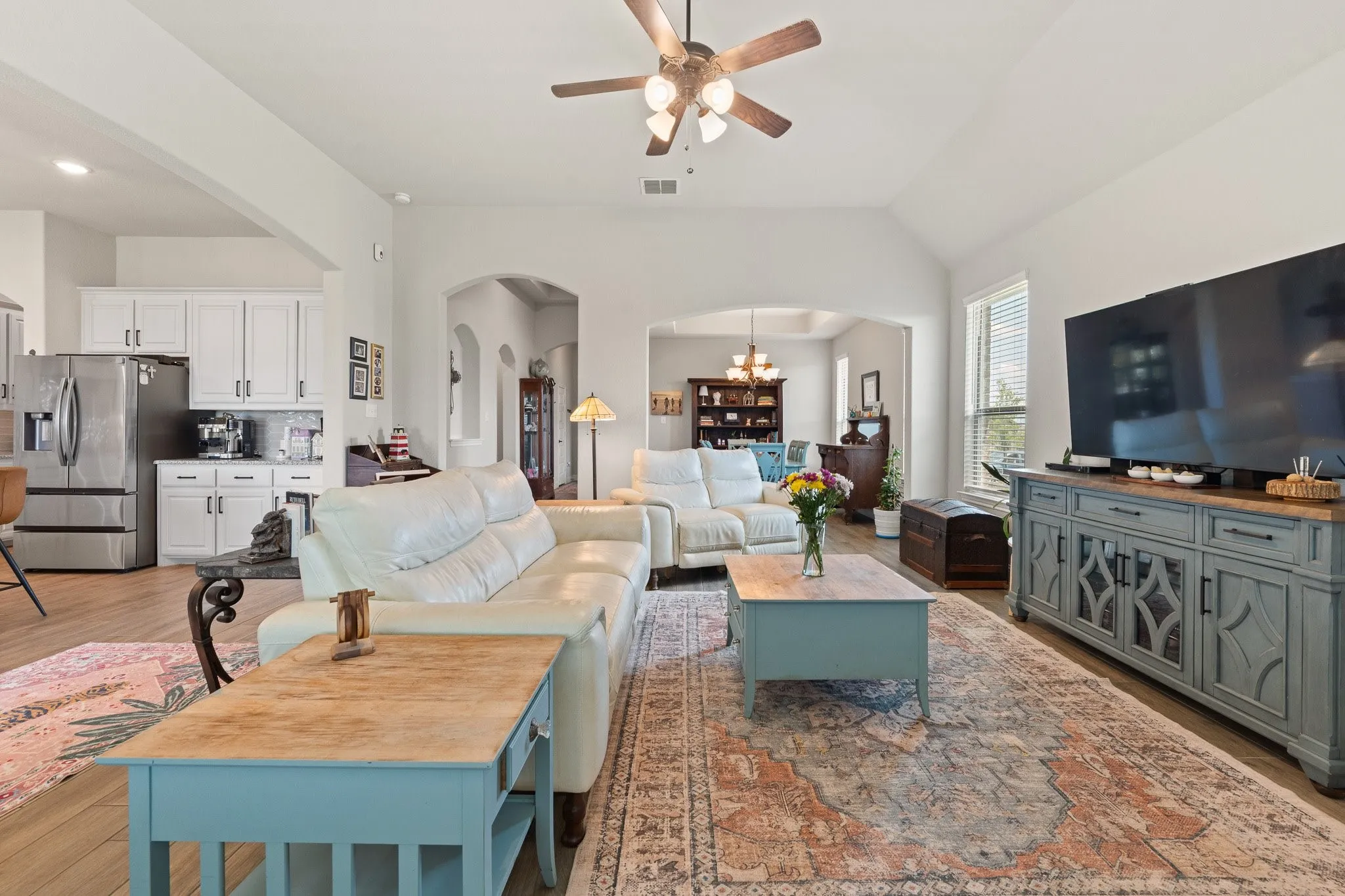 Spacious living area featuring vaulted ceilings, wood-finish flooring, and arched doorways