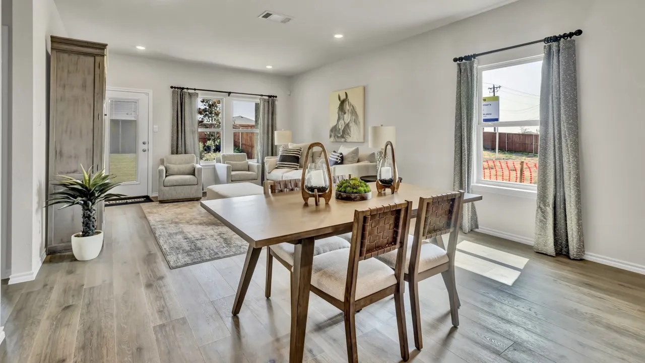 Open-concept living space featuring wood-finish flooring, recessed lighting, and a white paneled door with glass insert