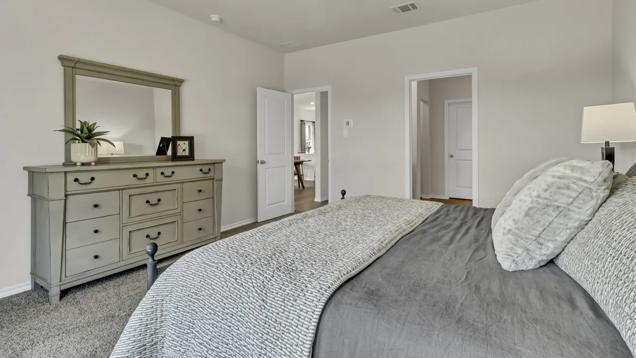 Carpeted bedroom with neutral wall paint and white trim