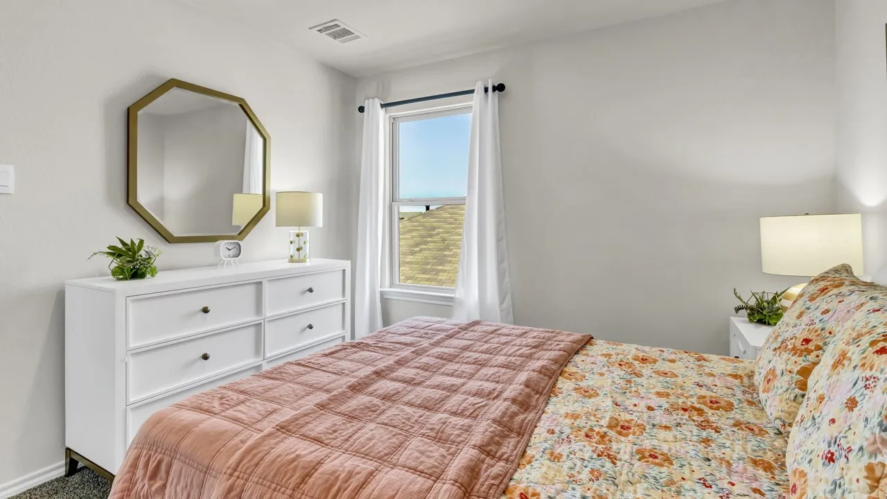 Bright room featuring a window with white curtains, white walls, and dark-framed window