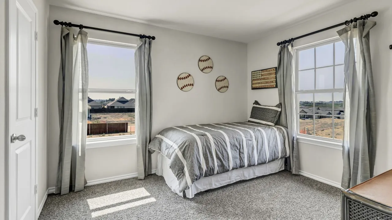 Spacious room featuring two large windows, light gray carpet, and white trim