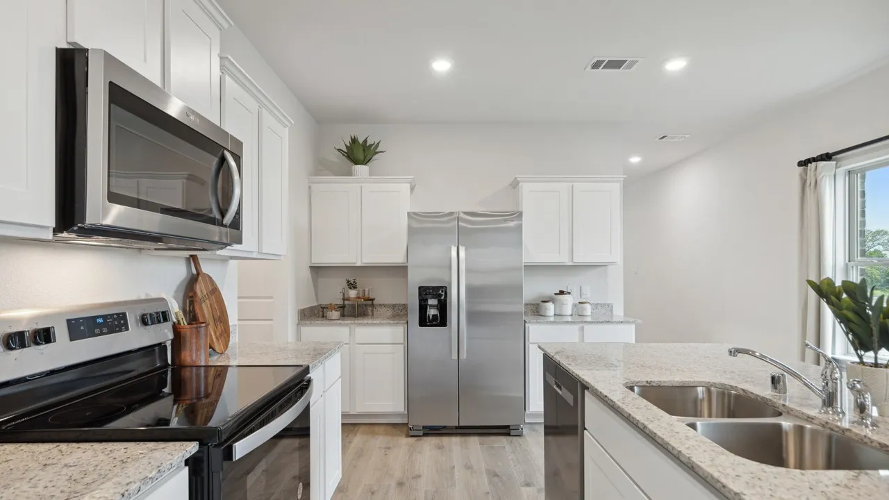 Contemporary kitchen featuring white cabinetry, stainless steel appliances, granite countertops, a double basin sink, and wood-finish flooring
