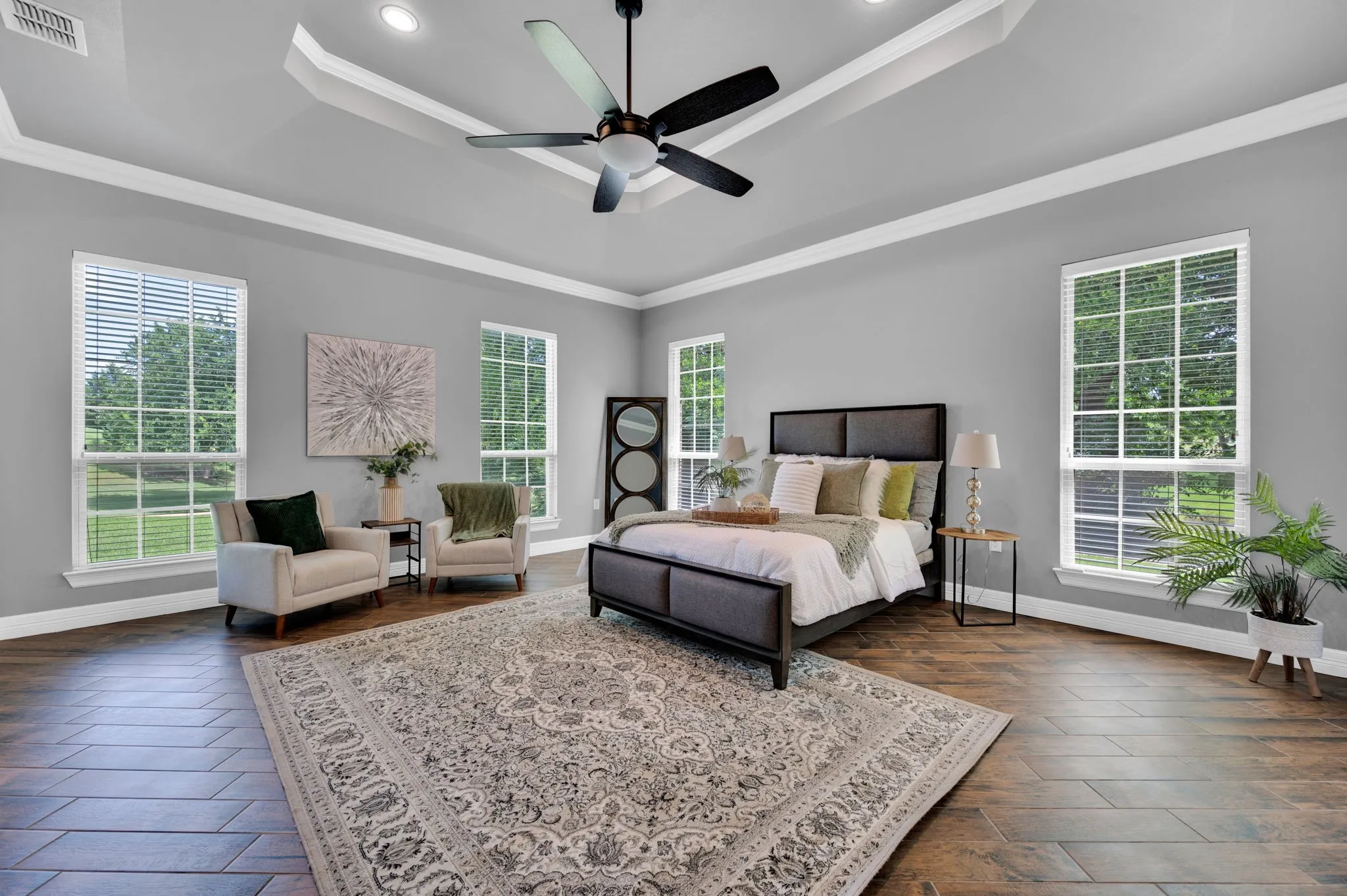 Oversized primary bedroom with tons of windows and door to access patio