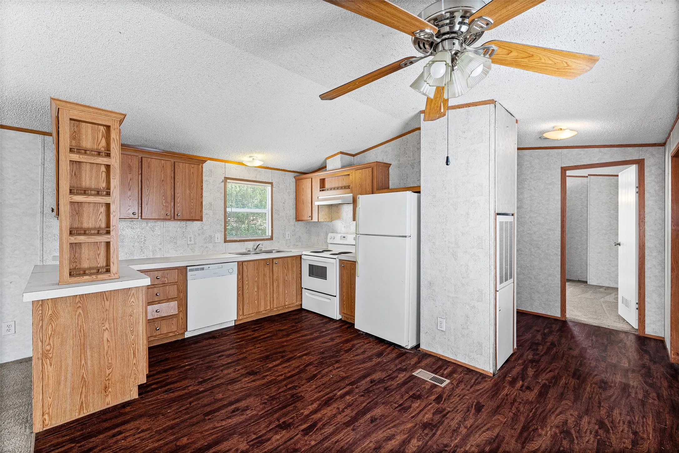 Kitchen featuring wood-finish cabinetry, white countertops, and white appliances