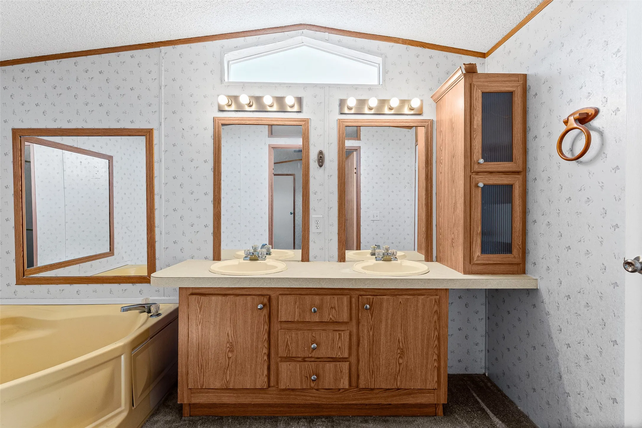 Dual vanity with light wood-finish cabinetry, integrated sinks, and matching mirrors