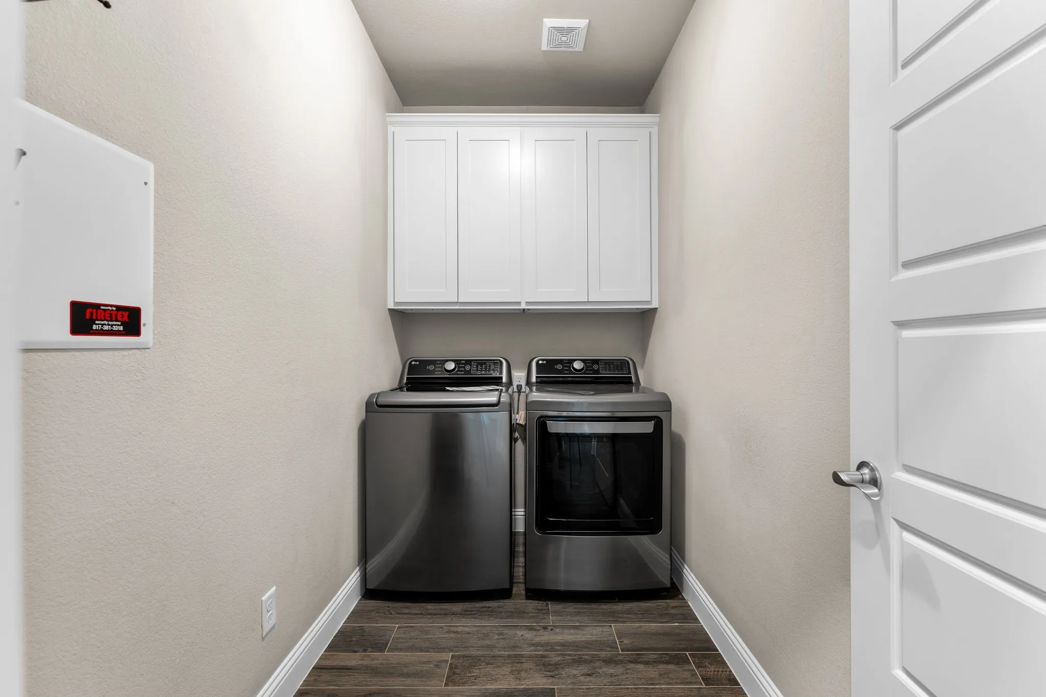 Deep laundry room, White painted cabinetry for storage in laundry room.