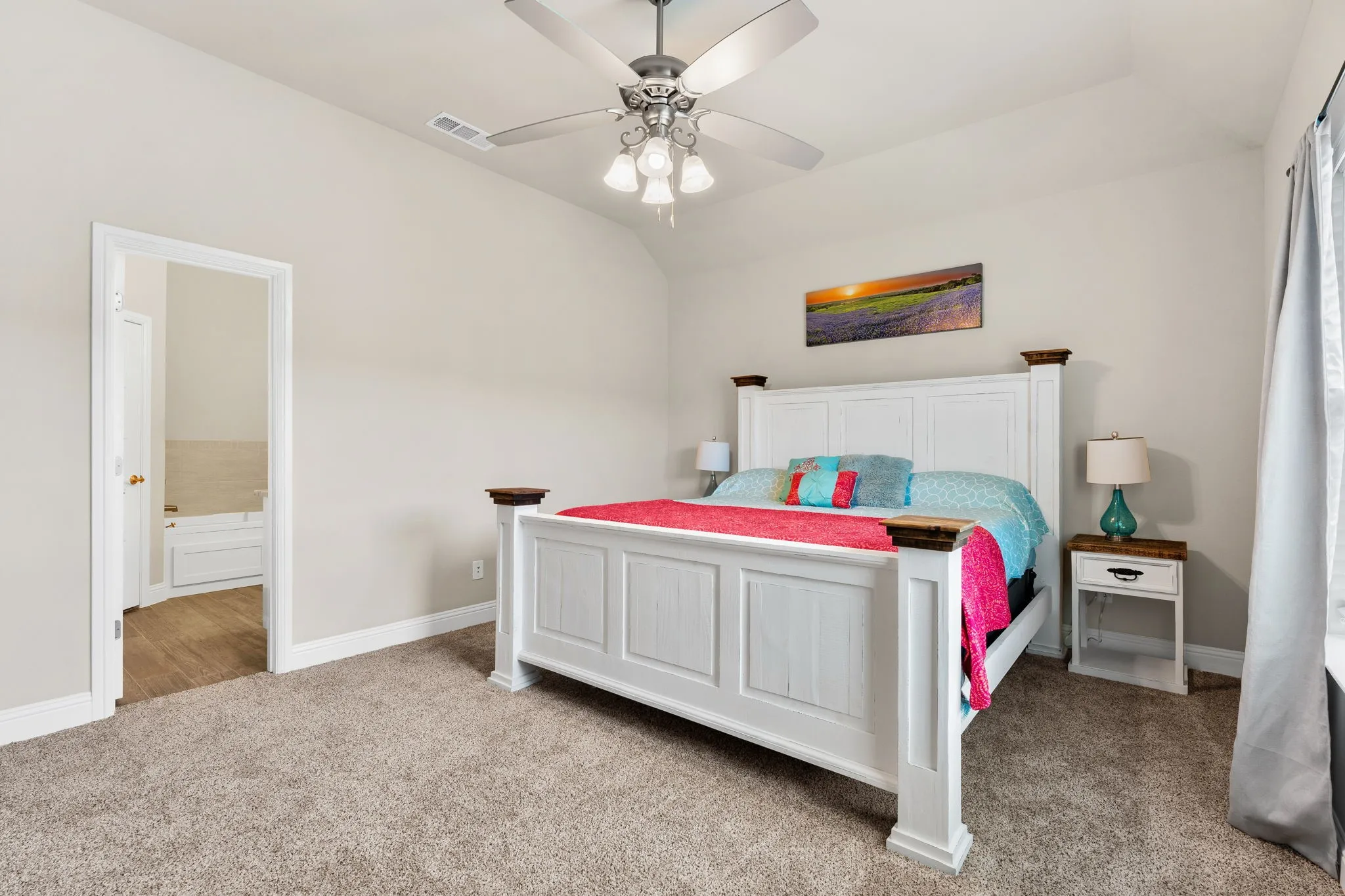 Large master bedroom with ceiling fan, windows for natural lighting.