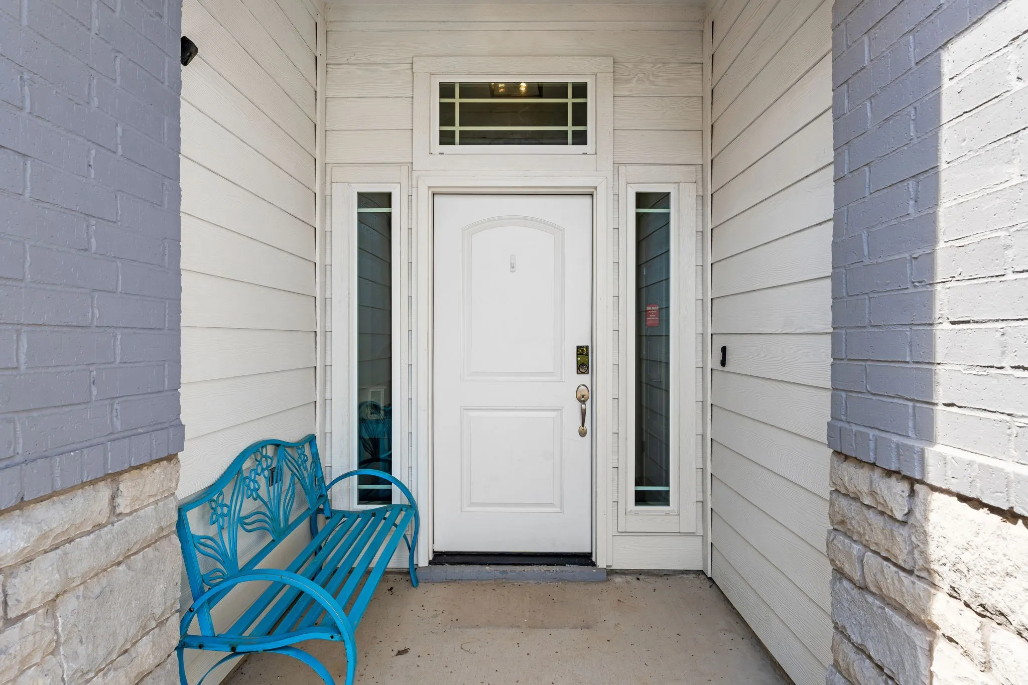 Front Exterior entry way with white siding, gray painted brick, stone, and decorative windows around door, along with code and thumb print lock!