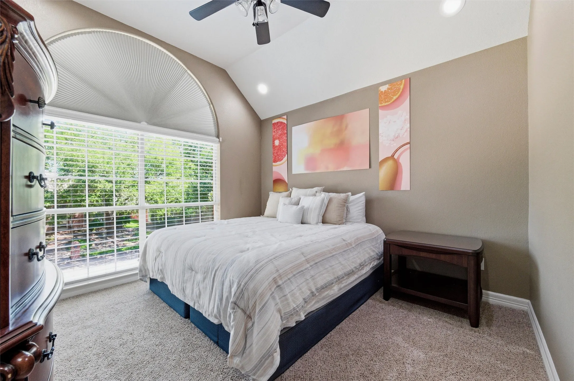 Front bedroom 3 with vaulted ceiling, recessed lighting, ceiling fan, and gorgeous arched window.