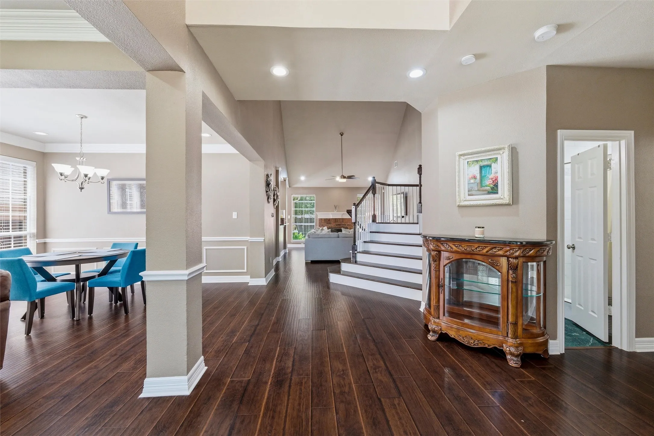 Engineered wood, stairs with white risers. Stacked formals to left, Study or BdRm 2 with French doors to right, Full Hall Bath at door to right. Primary Suite to right.