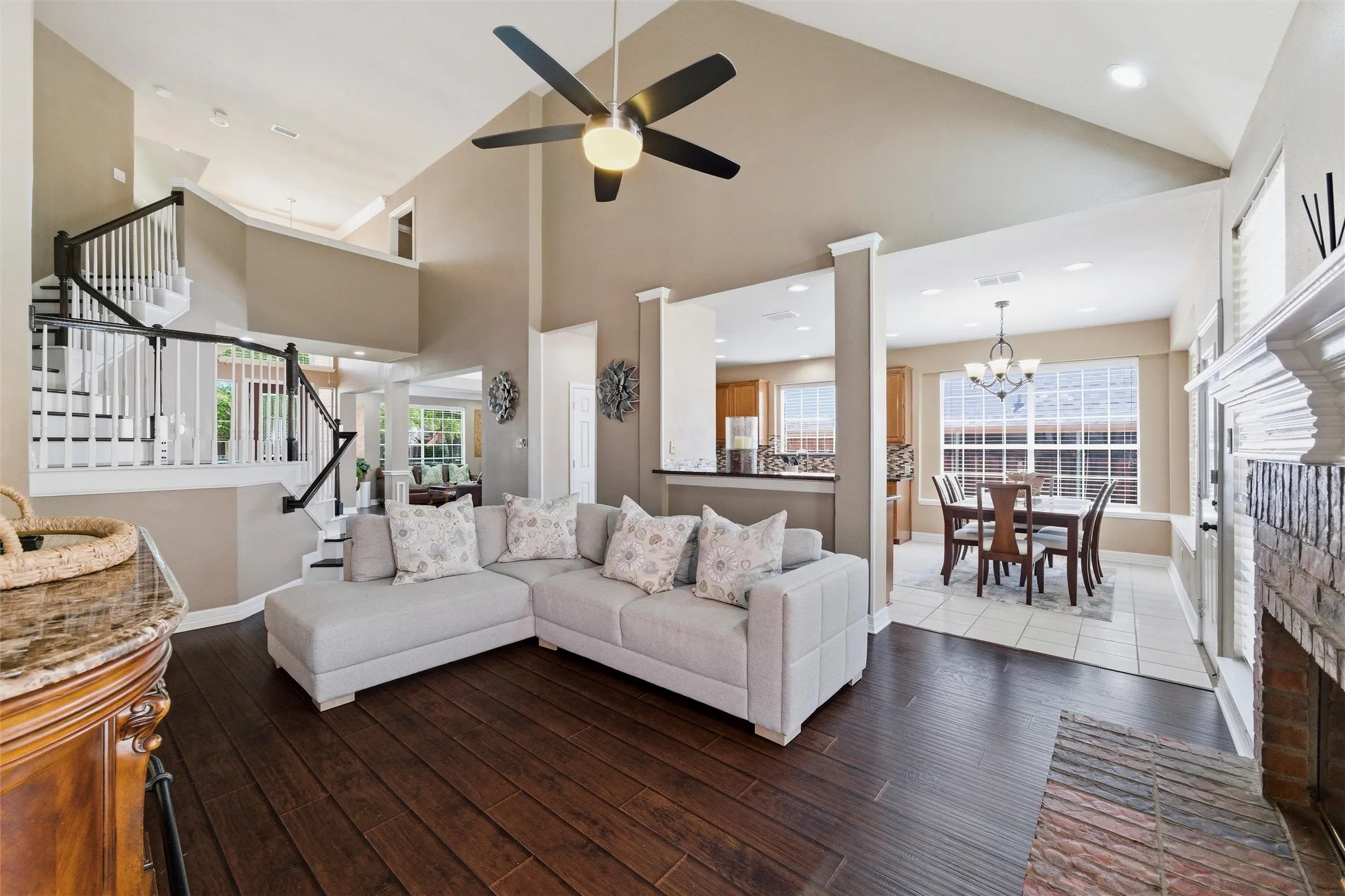 Family Rm has engineered wood, soaring ceiling, brick fireplace with gas start, elegant wood stairs, open to kitchen.