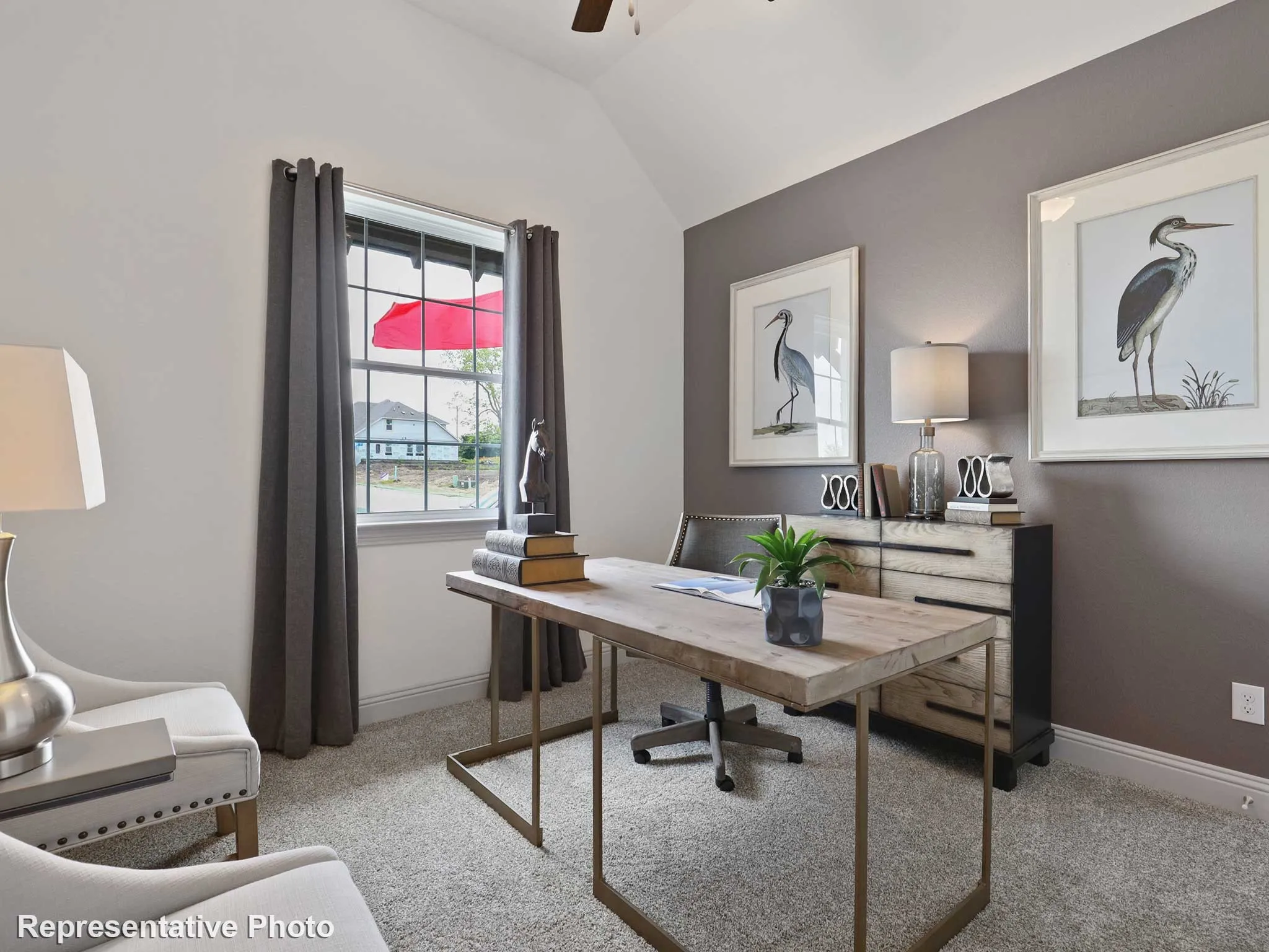 Vaulted ceiling with a ceiling fan, window with gray drapes, neutral carpet flooring, and a two-tone wall featuring a gray accent