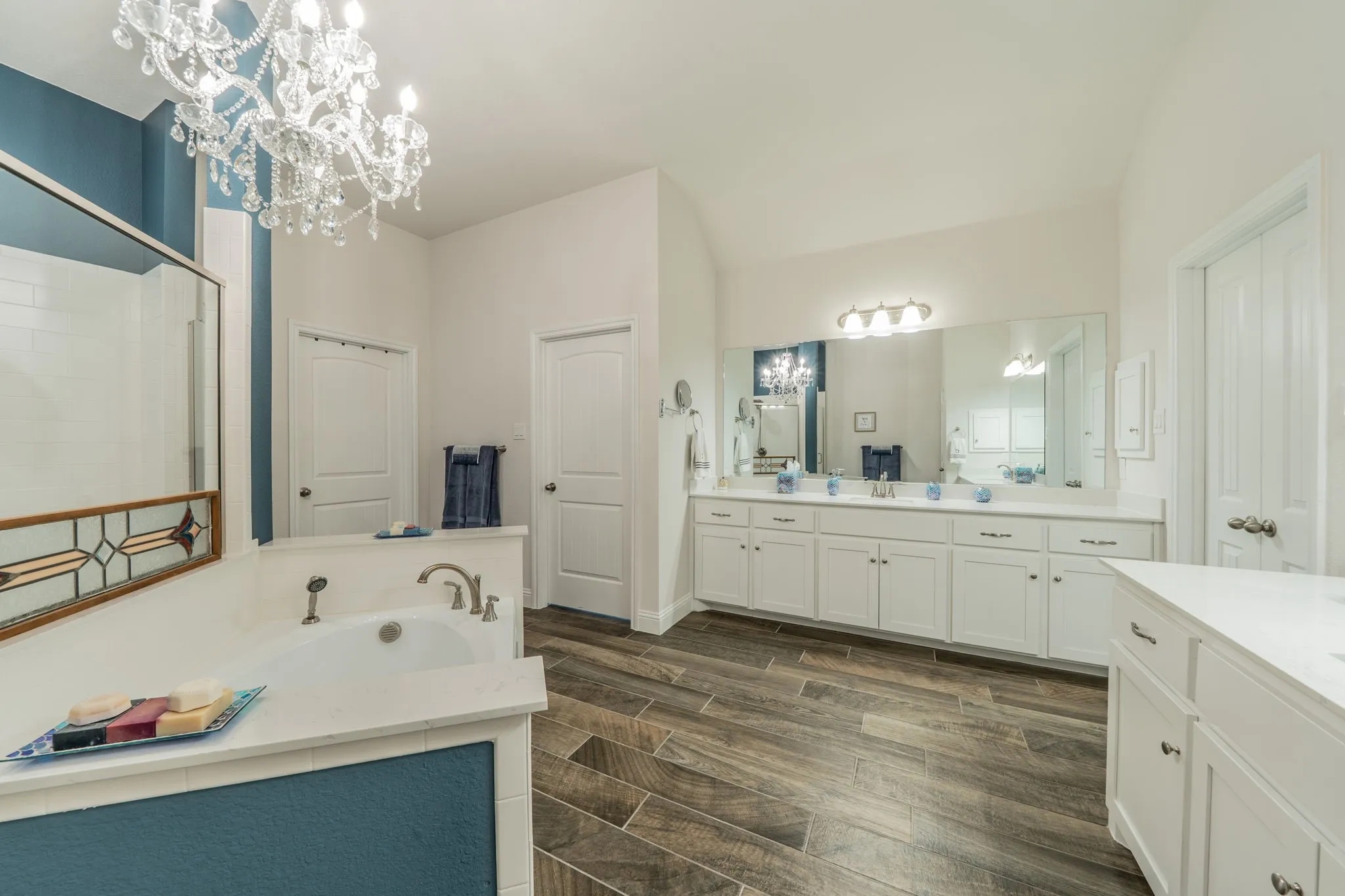 Expansive Master bathroom featuring a built-in tub with deck, a separate walk-in shower with glass enclosure, and a double vanity with ample counter space