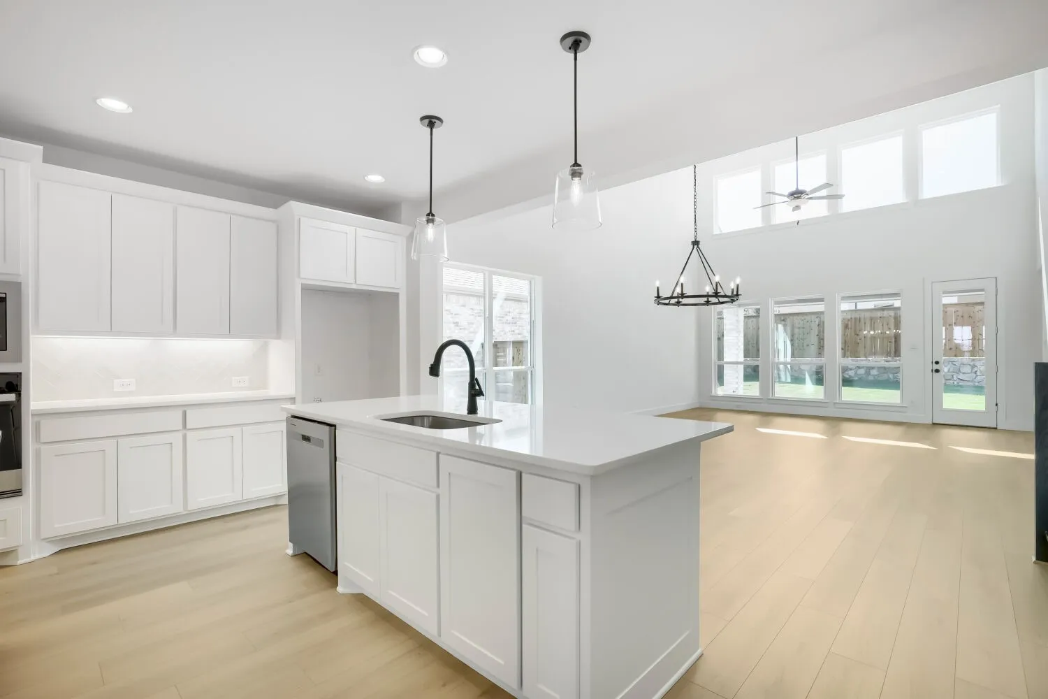 White kitchen cabinetry with a central island and undermount sink