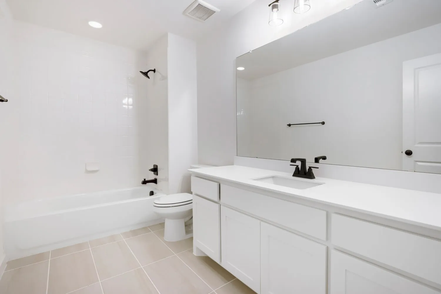 Bathroom featuring a white vanity with integrated sink, white countertop, and matte black fixtures