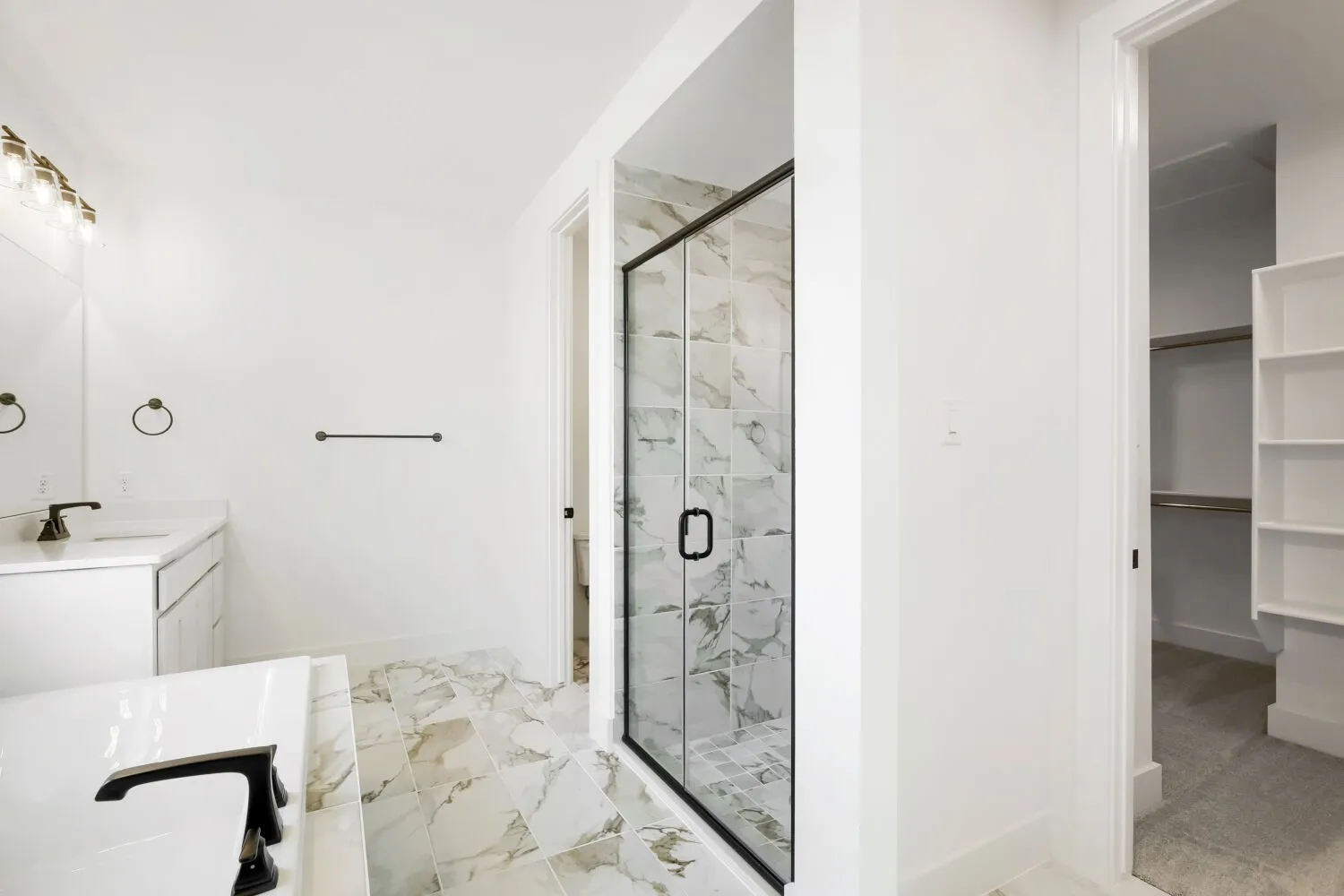 Spacious bathroom featuring a built-in bathtub, a walk-in shower with a glass enclosure, a single vanity with a white countertop, and patterned floor tiling