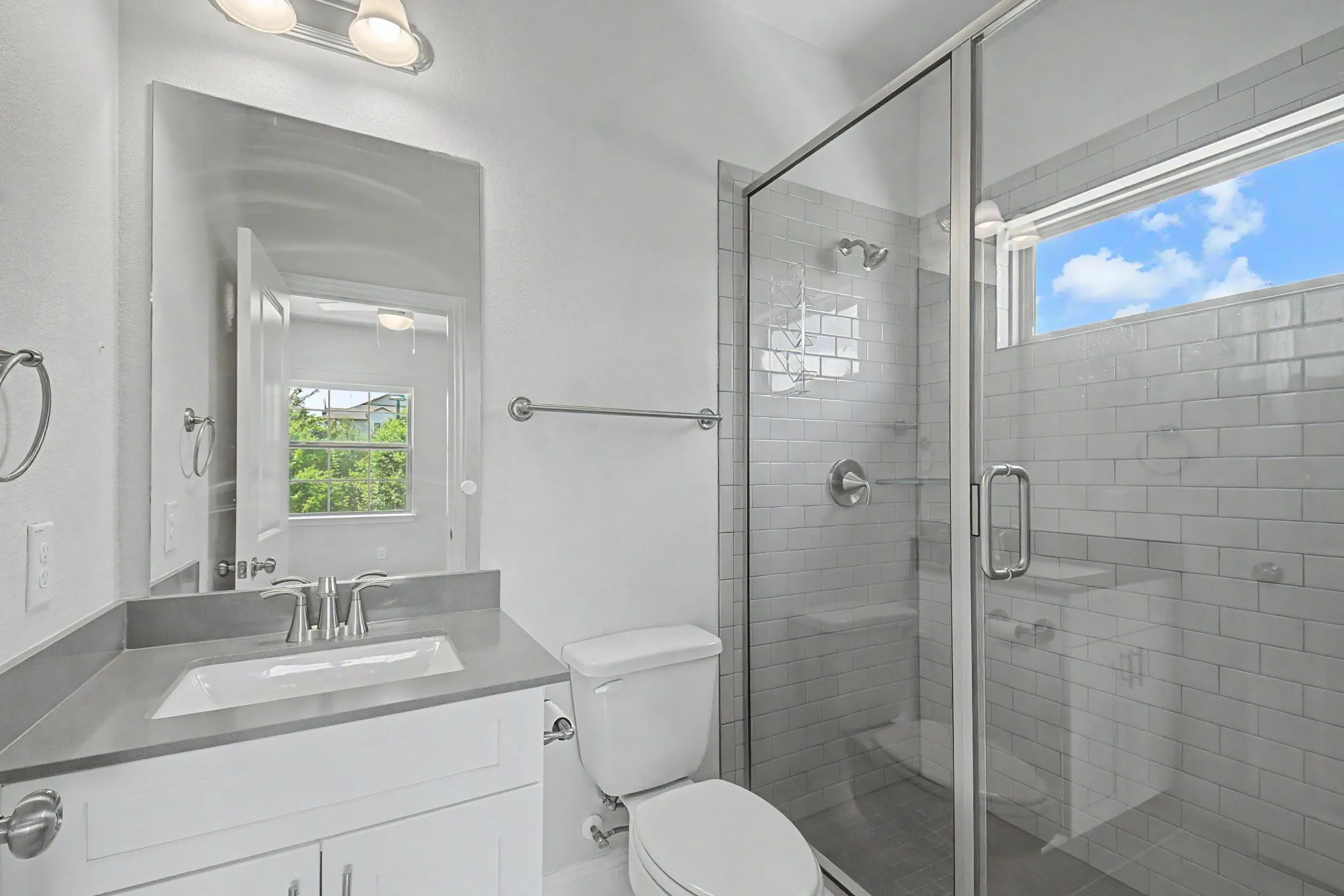Full bathroom featuring a glass-enclosed shower with subway tile surround, integrated shower bench, and a transom window