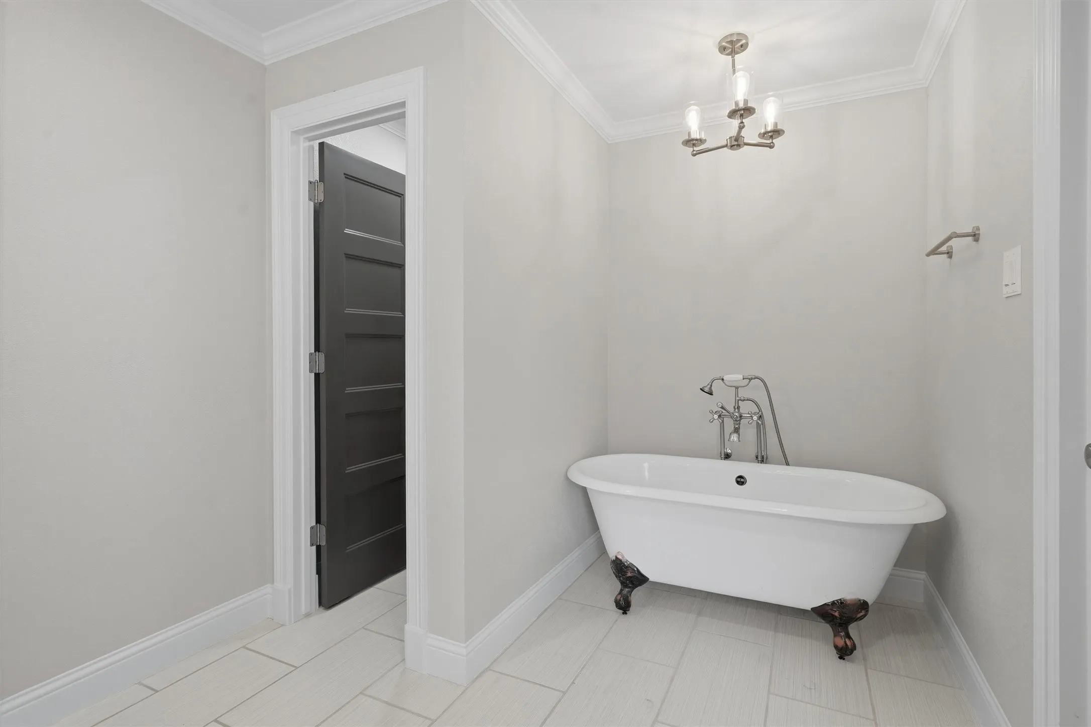 Freestanding clawfoot tub with a chrome faucet and shower wand