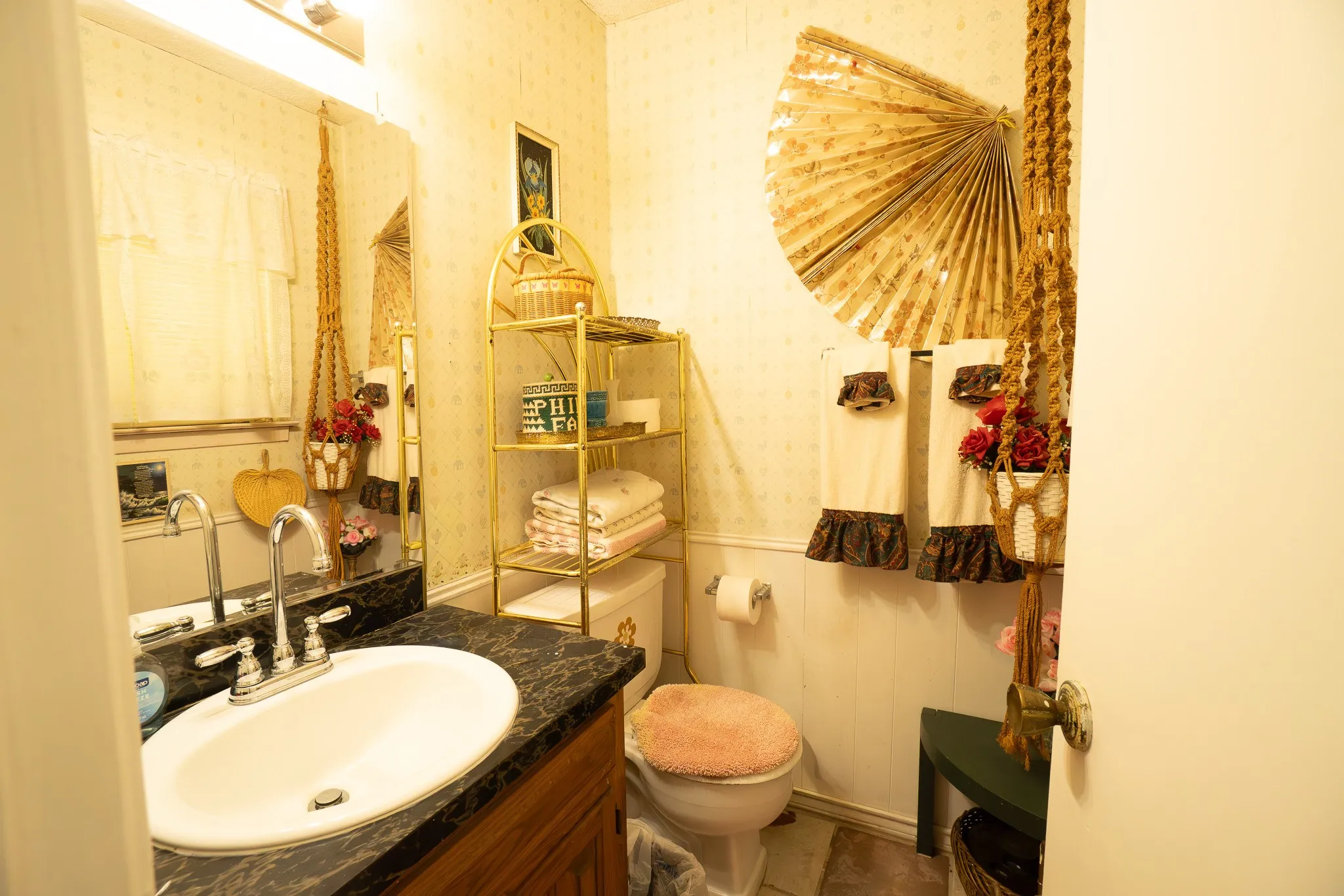 Bathroom featuring a white oval sink with chrome faucet, a dark countertop, and wood-finish cabinetry