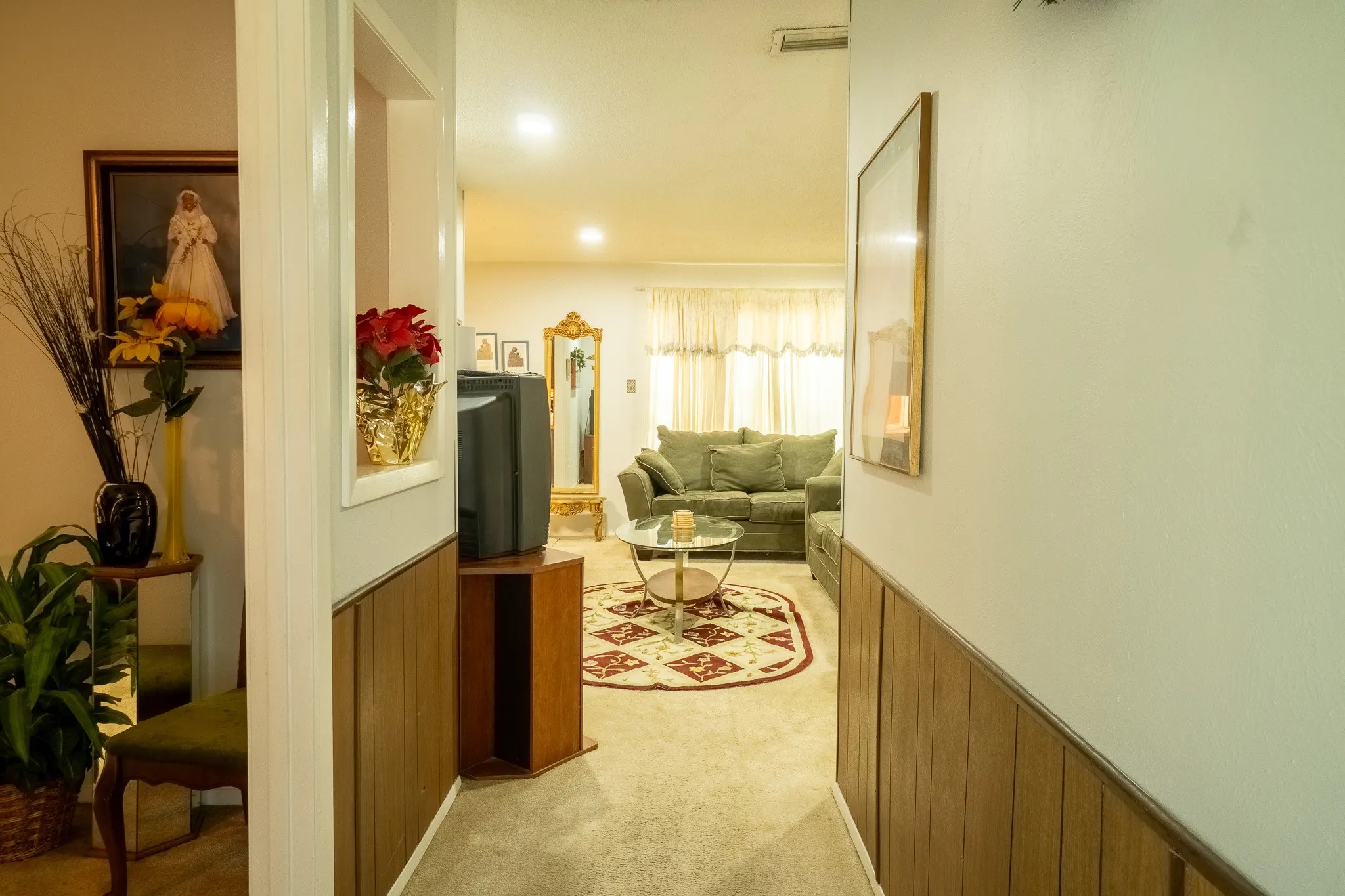 Hallway featuring wood paneling on lower walls and a decorative wall niche