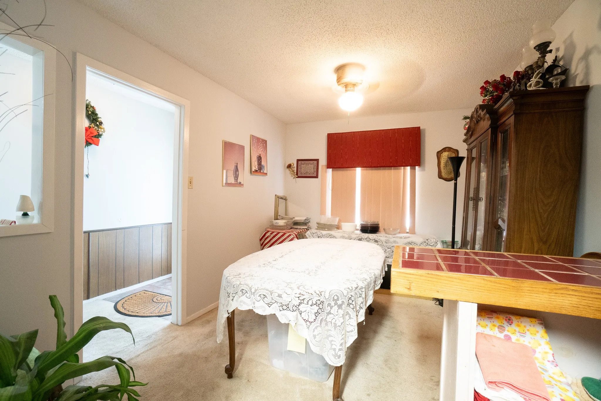 Carpeted interior space with a window featuring blinds and a valance, and a ceiling-mounted light fixture