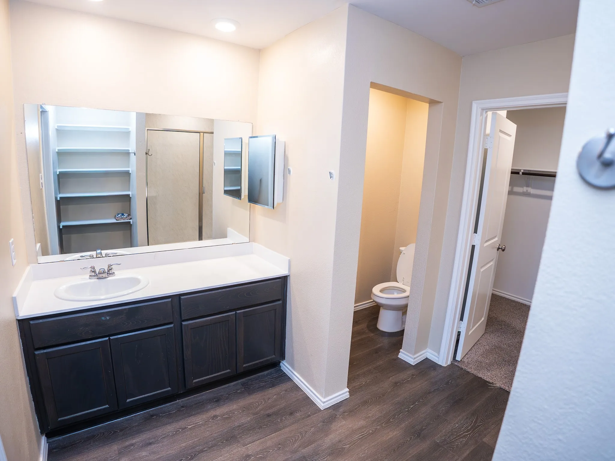 Vanity with integrated sink, dark wood-finish cabinetry, and white countertop