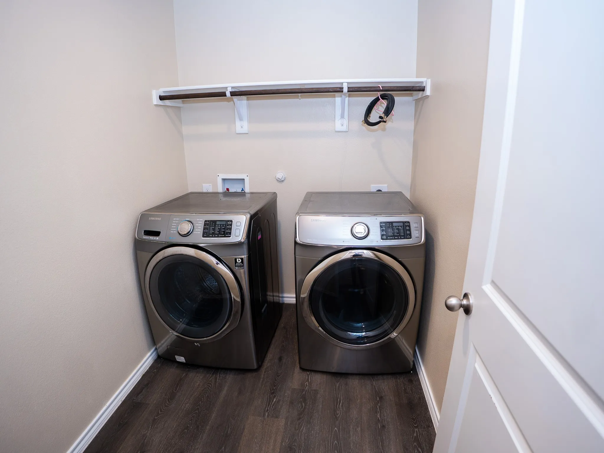 Dedicated laundry area featuring dark wood-finish flooring