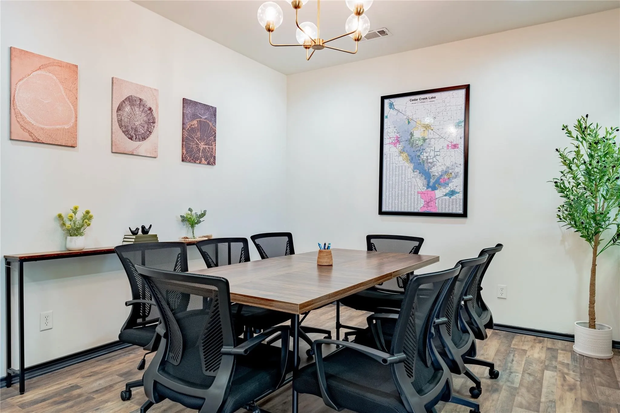 Meeting space featuring wood-finish flooring, a contemporary chandelier, and white wall finishes